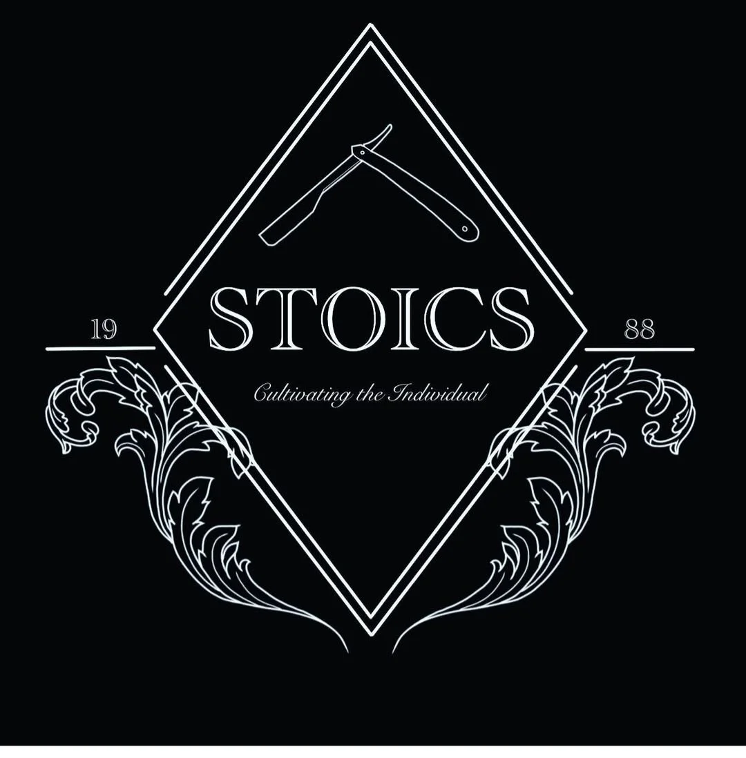 Black and white photo of a person wearing a hoodie and cap standing in a corridor with glass walls and ceiling lights.