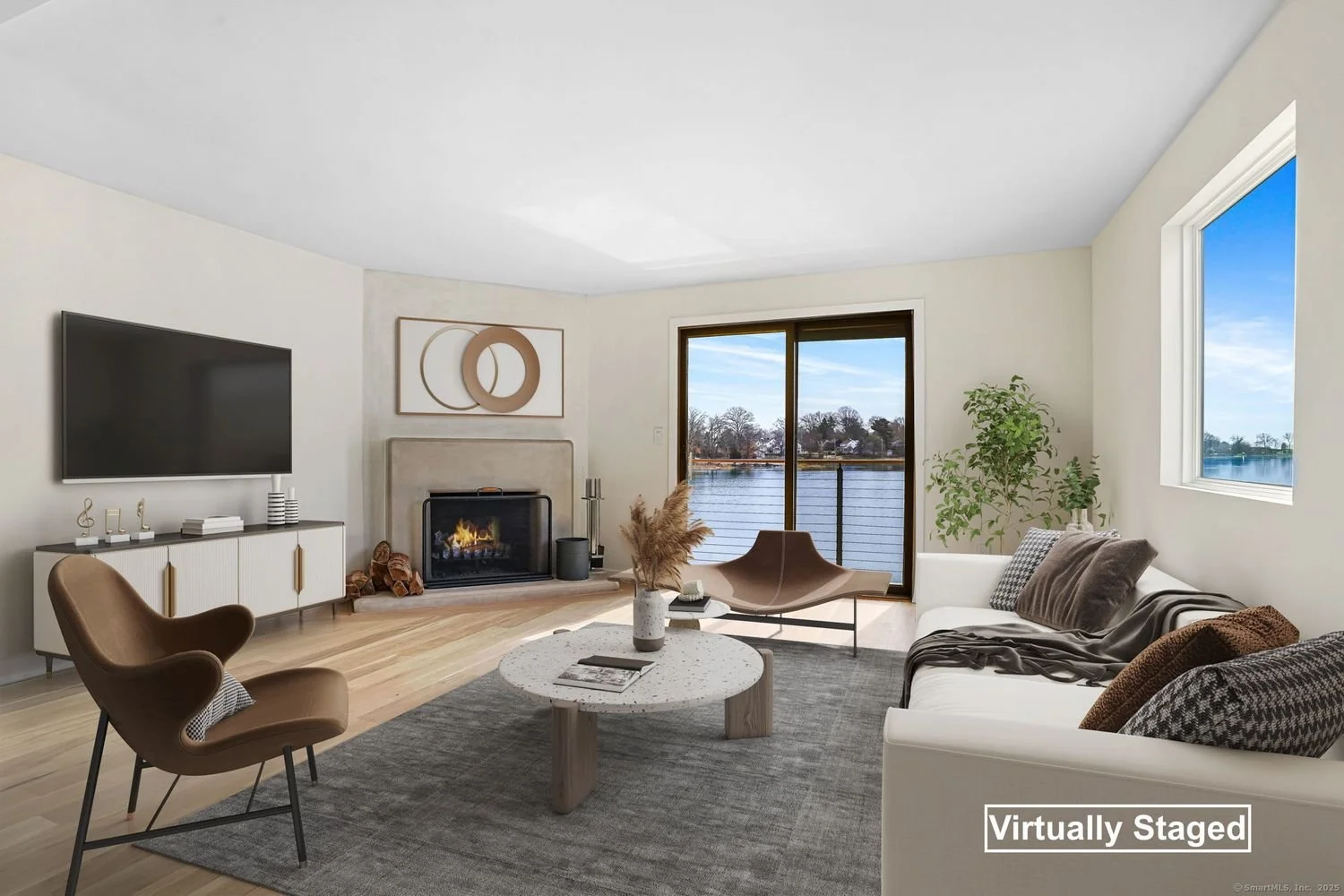Virtually staged living room with modern furniture, fireplace, large window with lake view, coffee table, and TV.