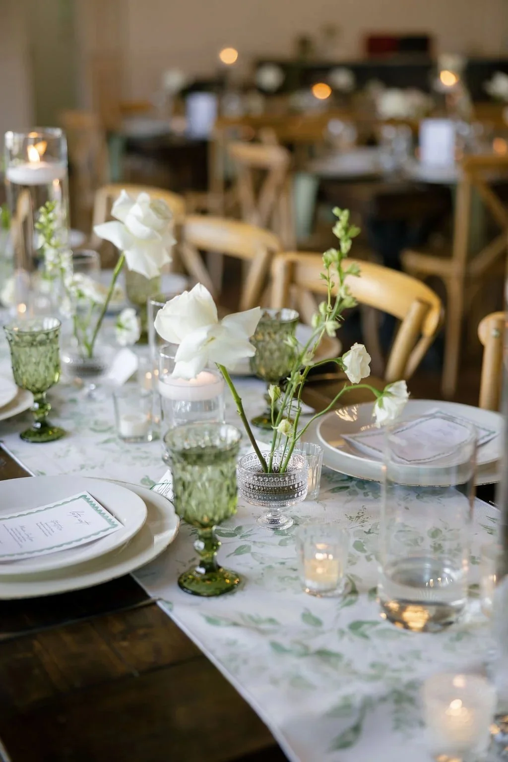 Reception table with greenery, candles and white blooms