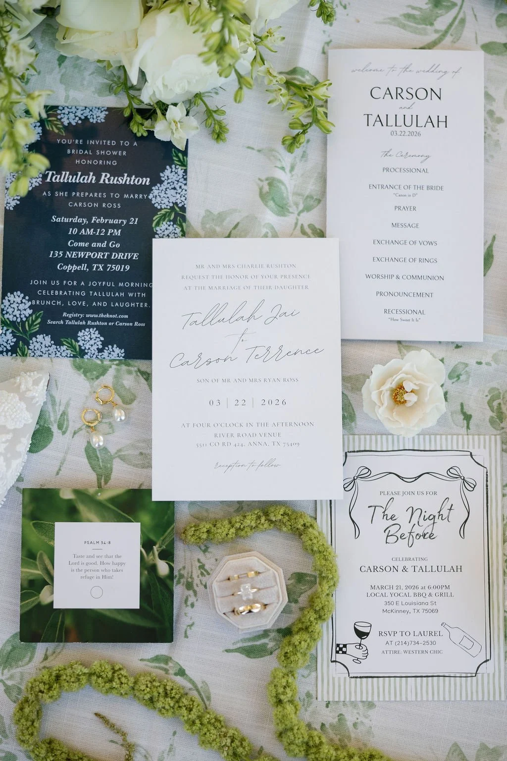 A classic white and blue and green wedding stationery, next to a brides rings