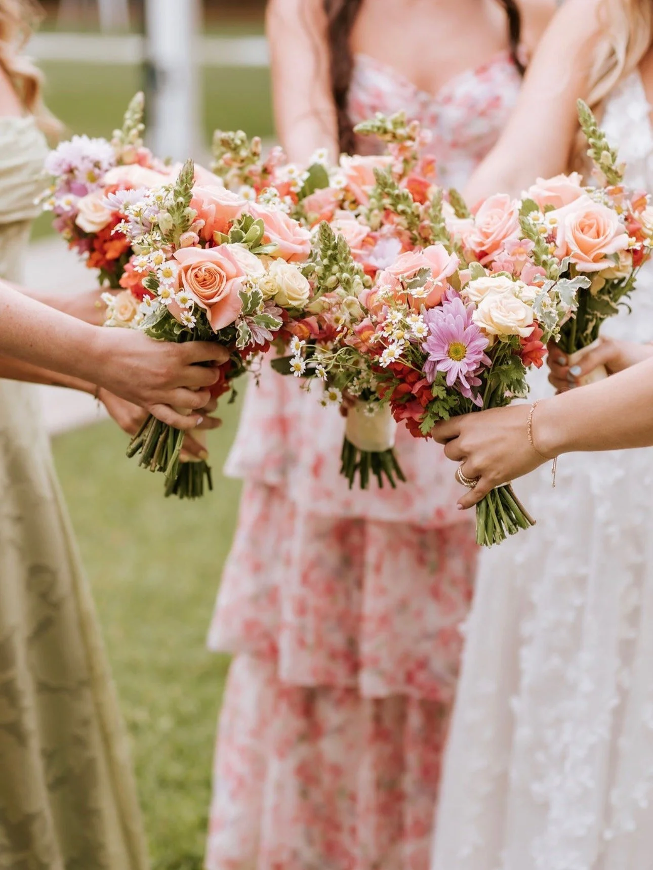 Close view of bridesmaids holding peach, pink, blush and lavender bouquets (flower types unsure)