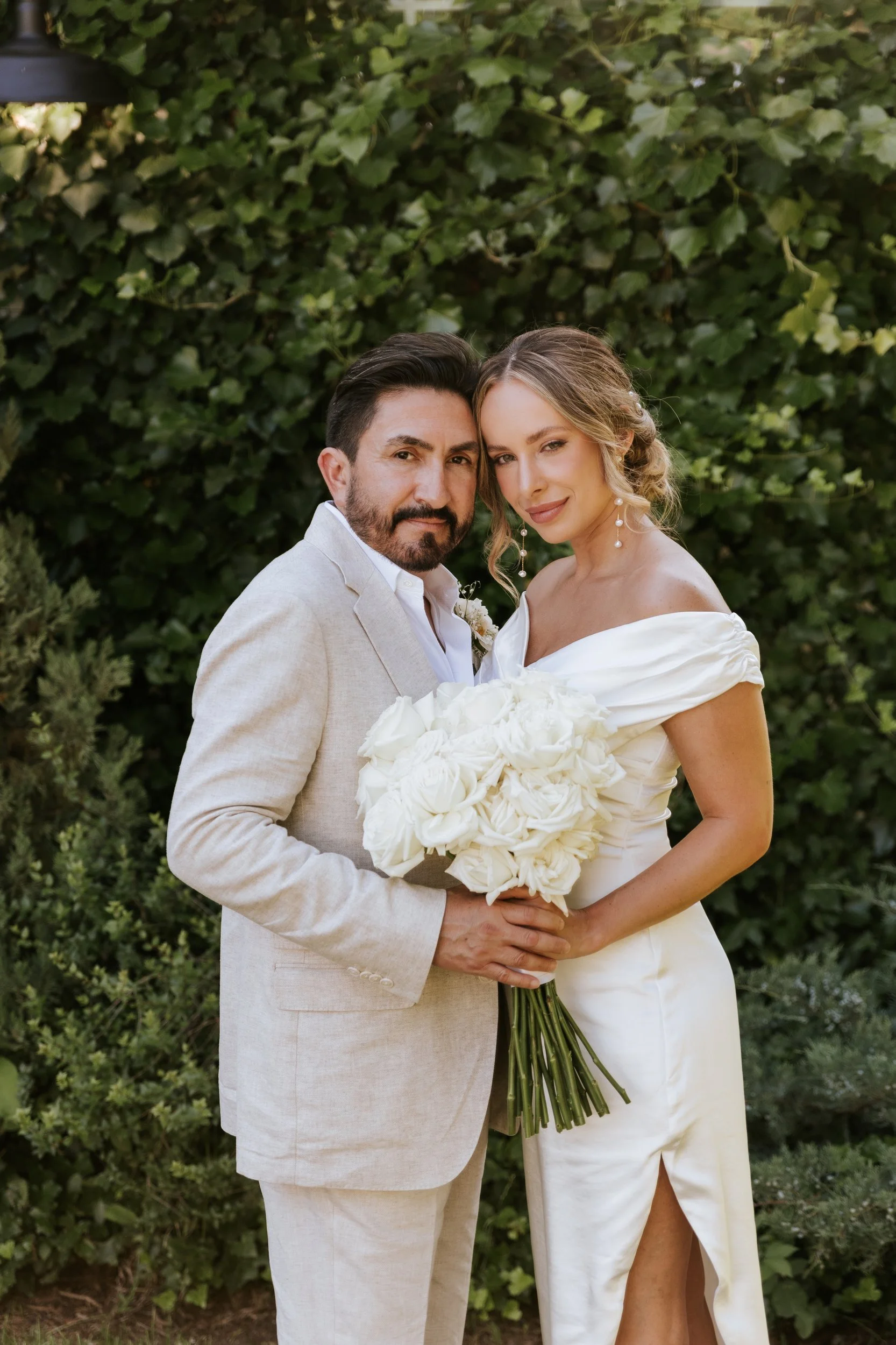 Bride and groom outdoors, the bride holding a white bouquet
