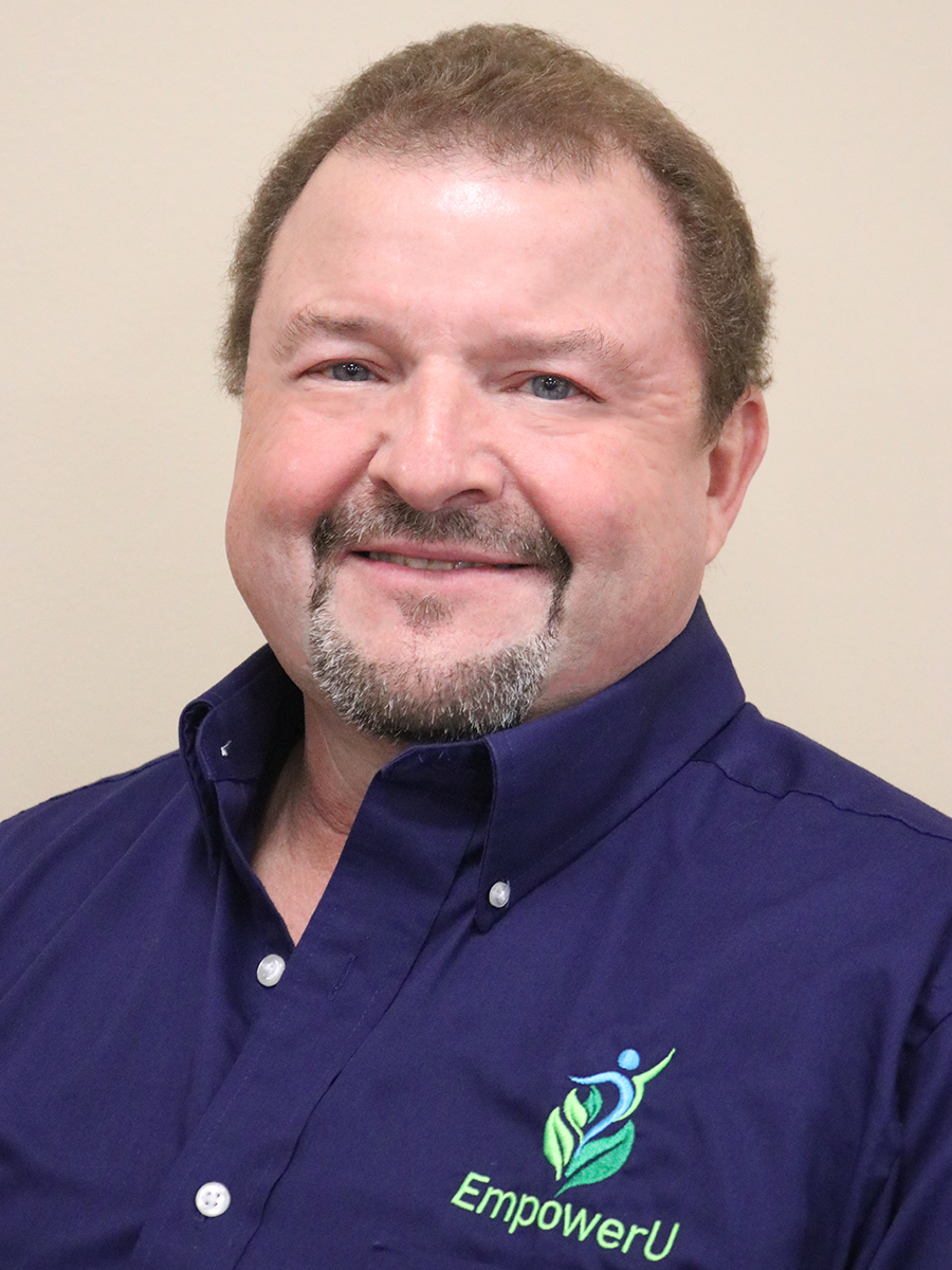 Portrait of a smiling man wearing a dark blue shirt with "EmpowerU" logo.
