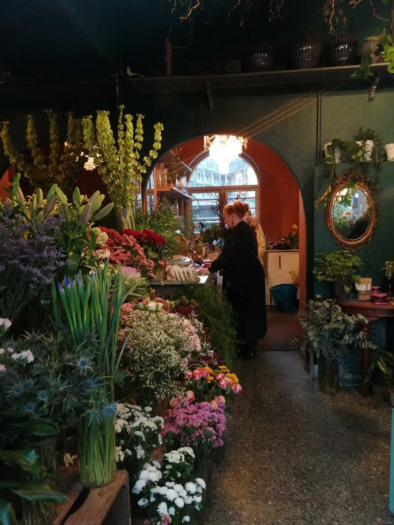 BlomsterHexen i hendes magiske blomsterbutik interiør med farverige blomster.
BlomsterHexen in her magic flower shop interior with colorful flowers.