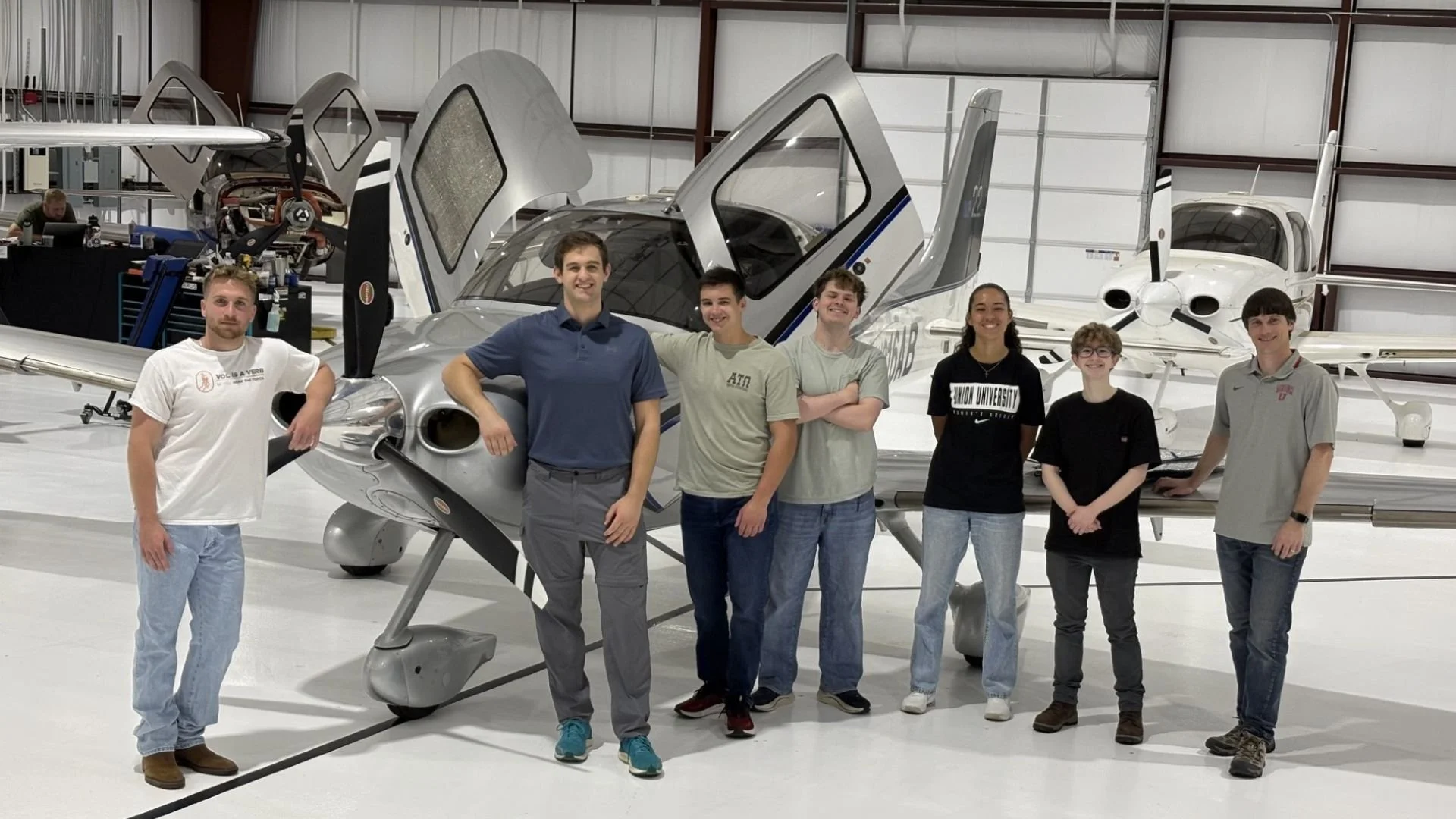 Students standing around airplane