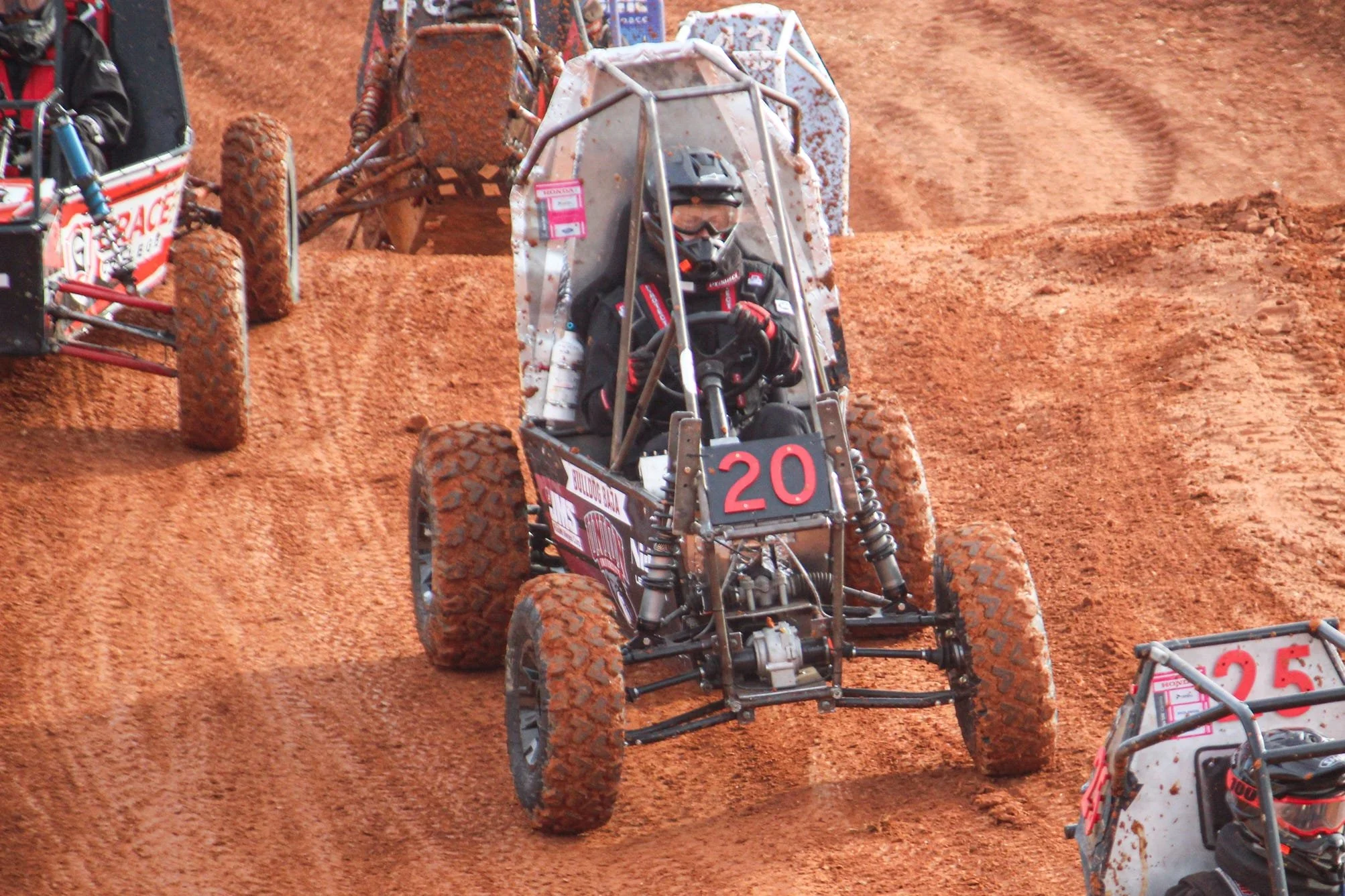 4 college students standing next to SAE Baja offroad vehicle