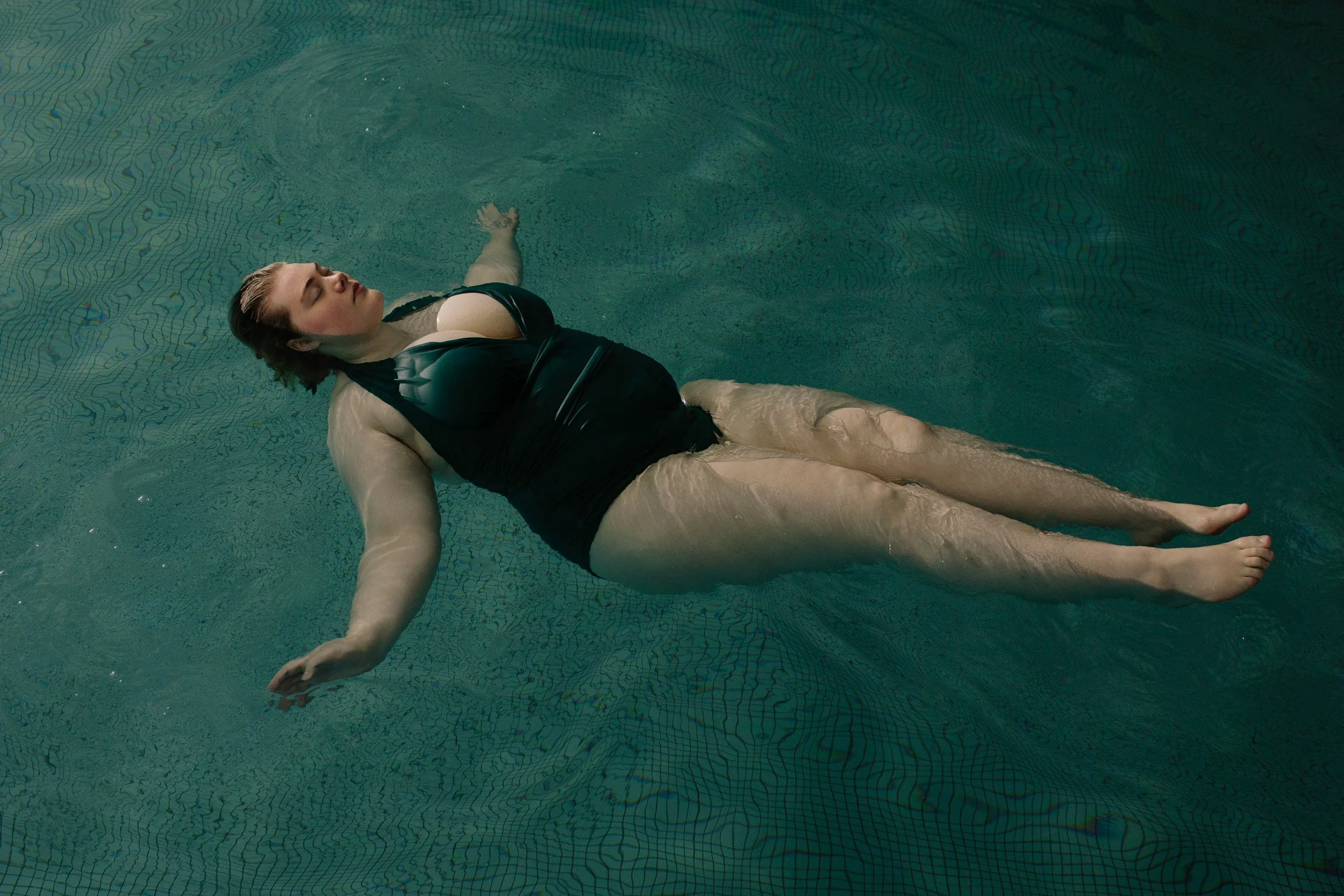 Ísold Halldórudóttir, floating in water,  photographed by Katharina Poblotzki