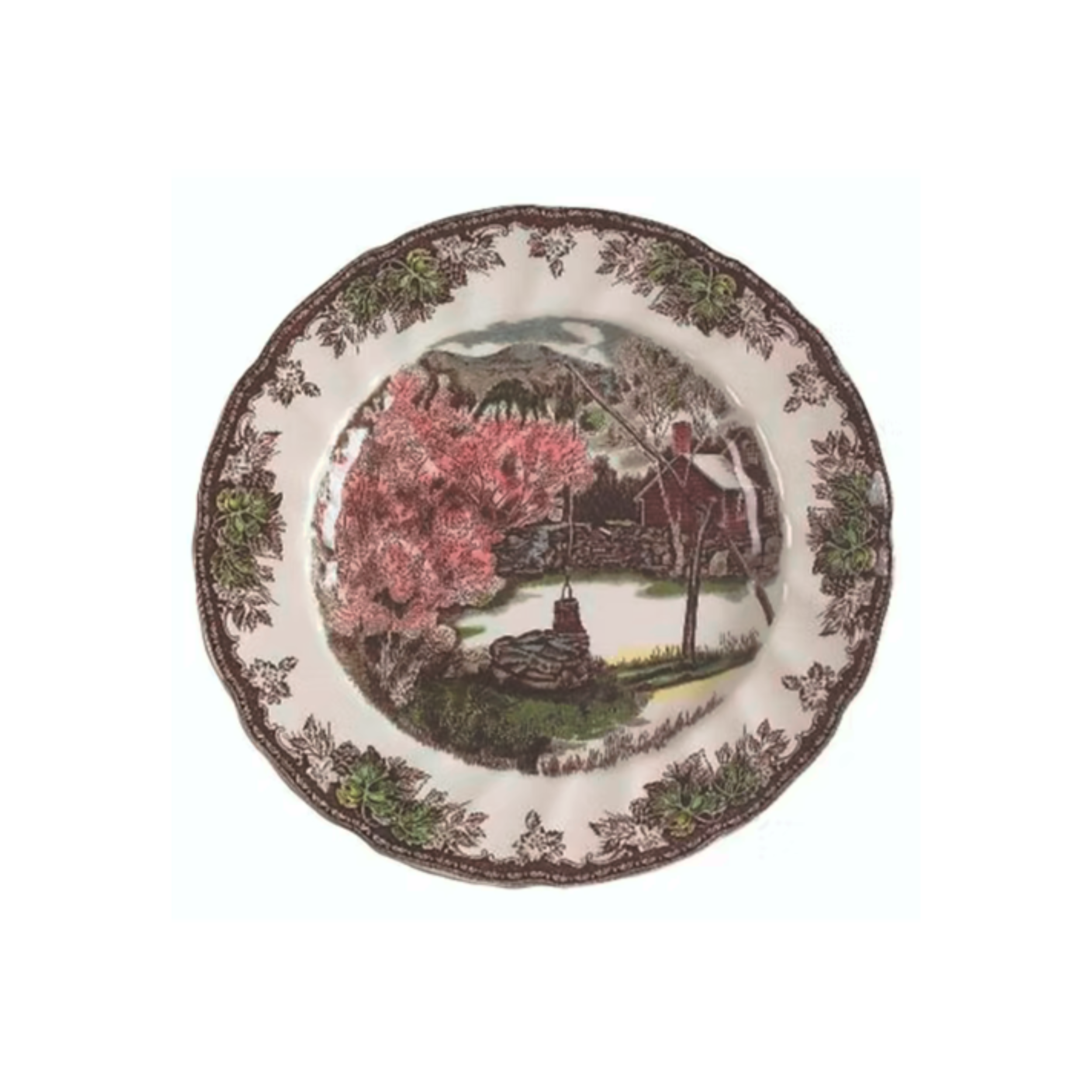 Decorative ceramic plate with a rural landscape painting featuring a windmill, a barn, pink trees, and green foliage, surrounded by a floral border.