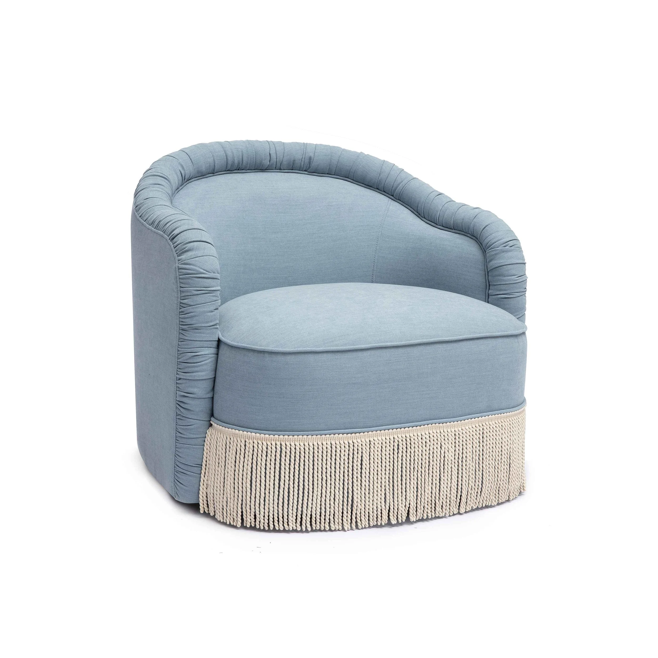 Light blue upholstered armchair with rounded arms and a fringed cream-colored base.