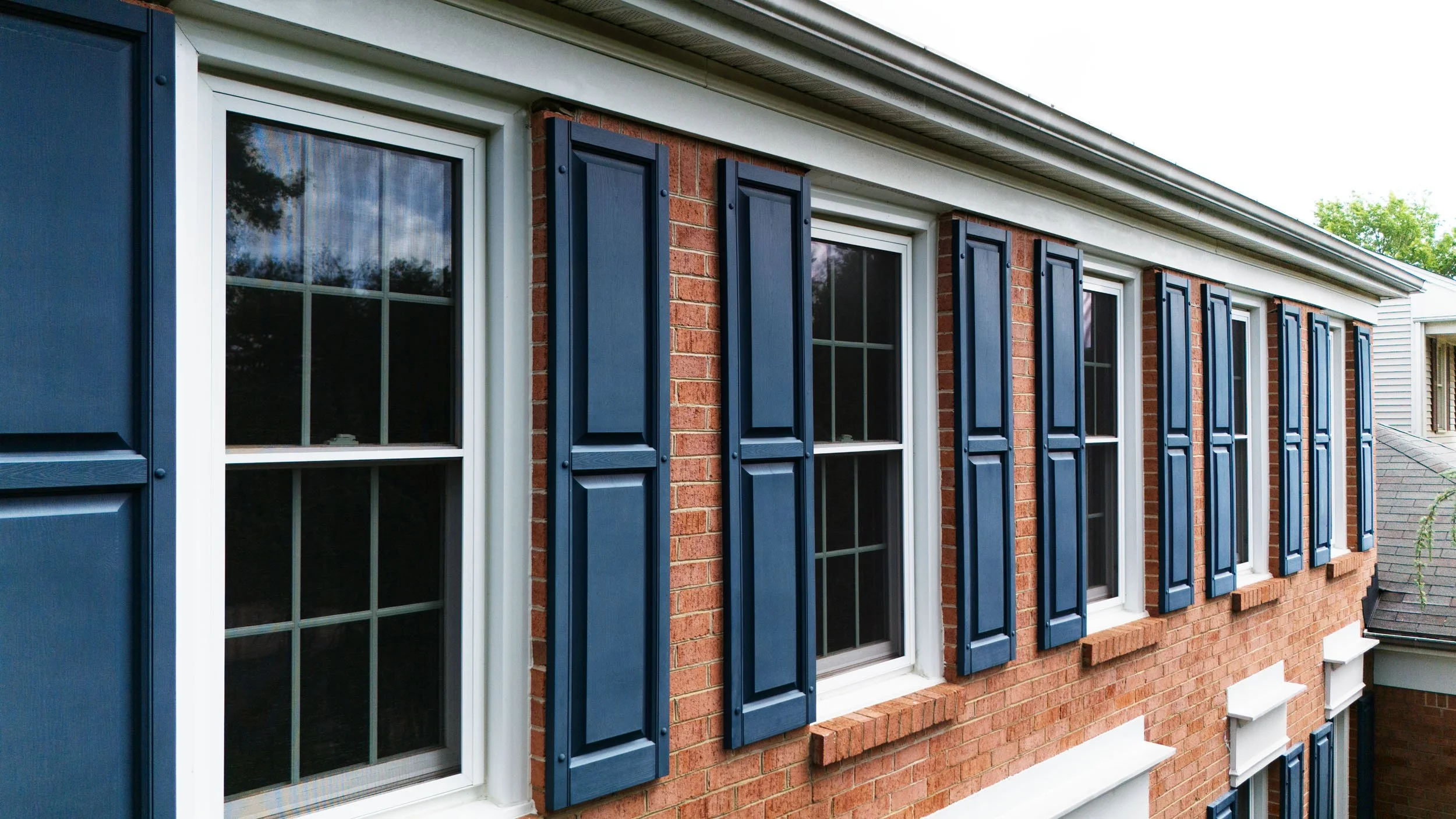20250729-4seasonshome-rockville-window-blue-shutters-installation-red-brick-colonial-angled-2500.jpg