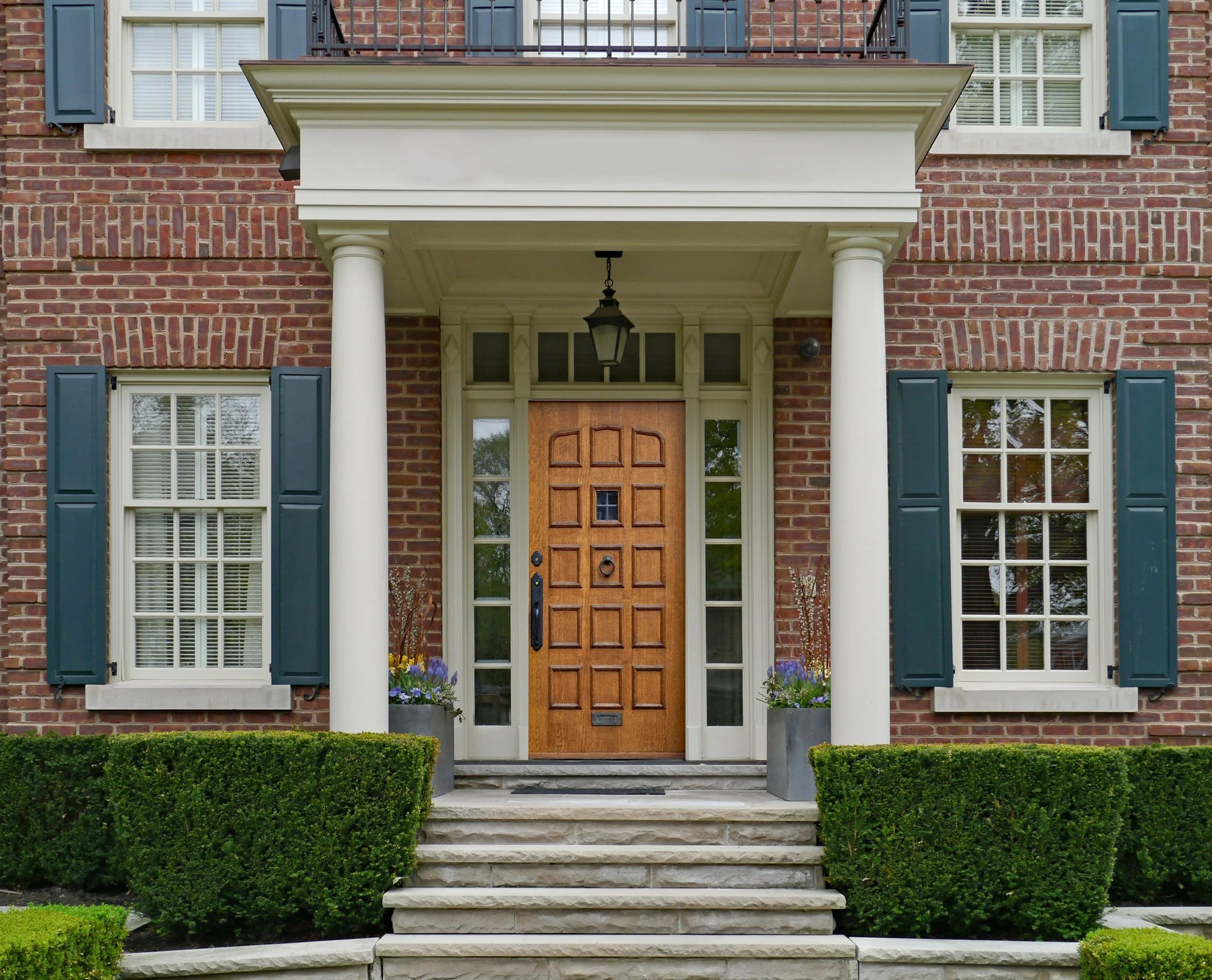 20250719-4seasonshome-rockville-red-brick-colonial-covered-porch-wood-paneled-door-transom-window-sidelights-white-framed-windows-shutters-2500.jpg