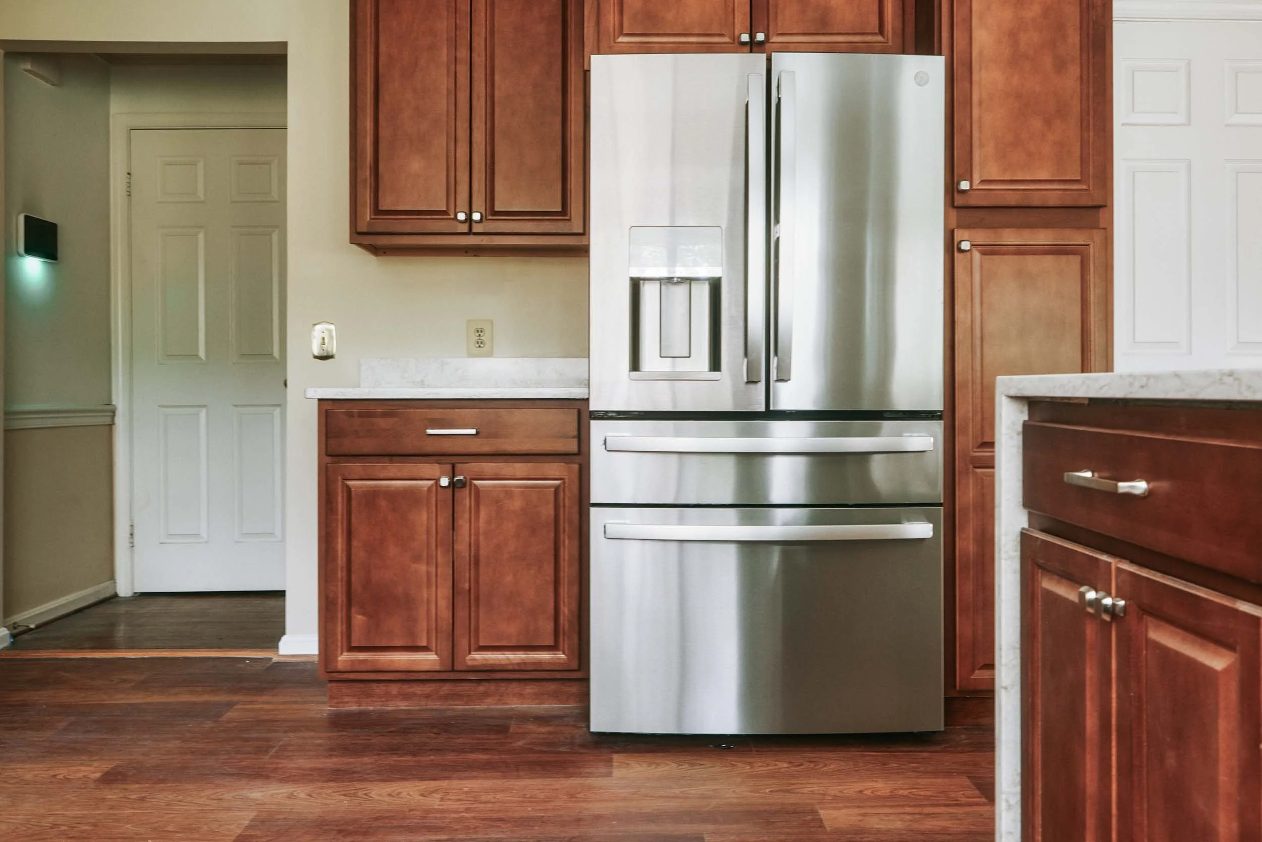 Kitchen with wooden cabinets and stainless steel refrigerator.