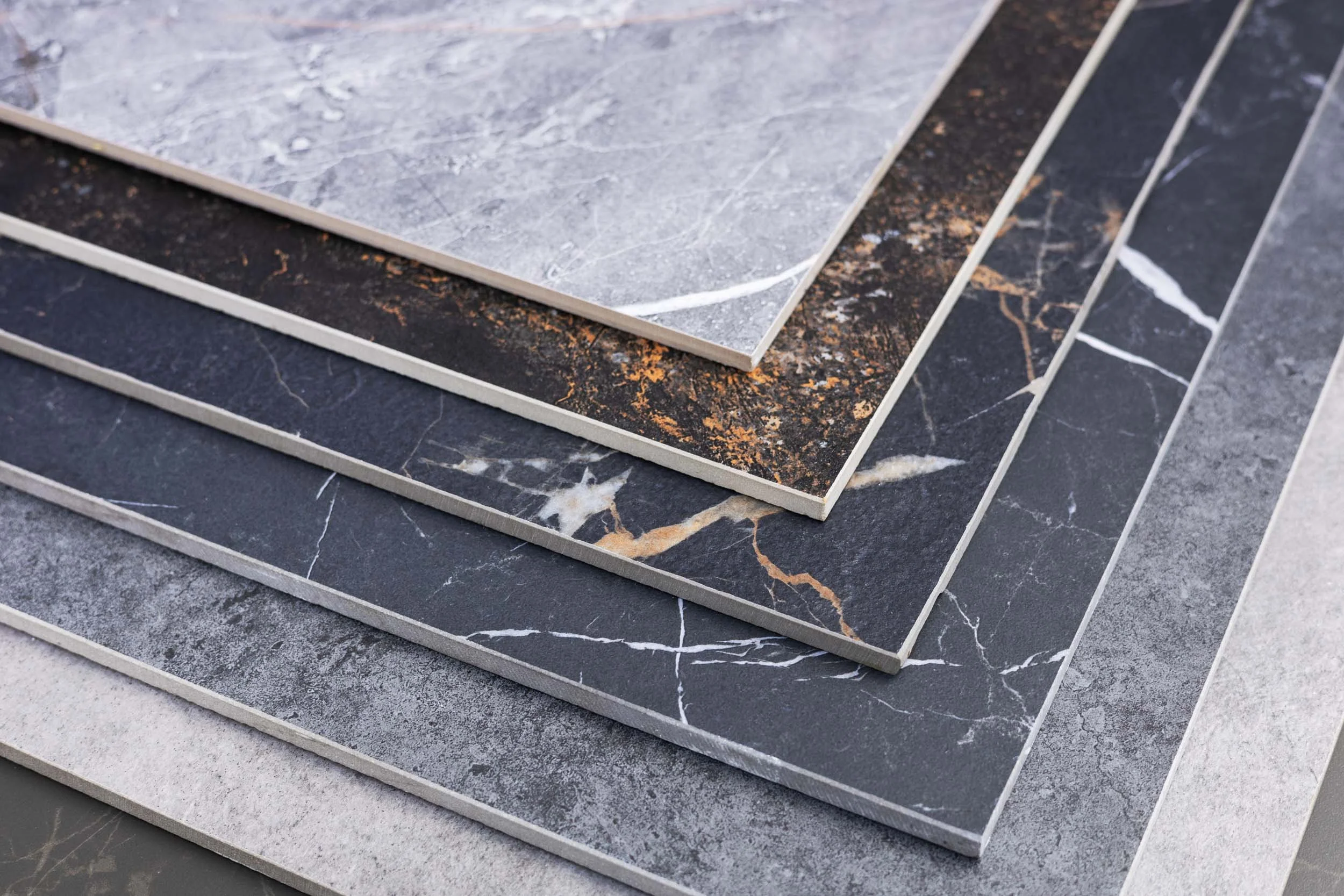 Samples of marble and stone tiles with various patterns and colors, arranged in a fan shape.