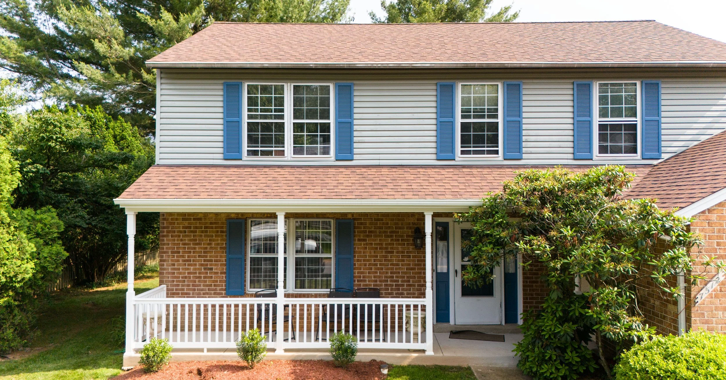20250726-4seasonshome-rockville-grey-siding-red-shingle-roof-blue-shutter-house-covered-porch-facade-2500x1308.jpg
