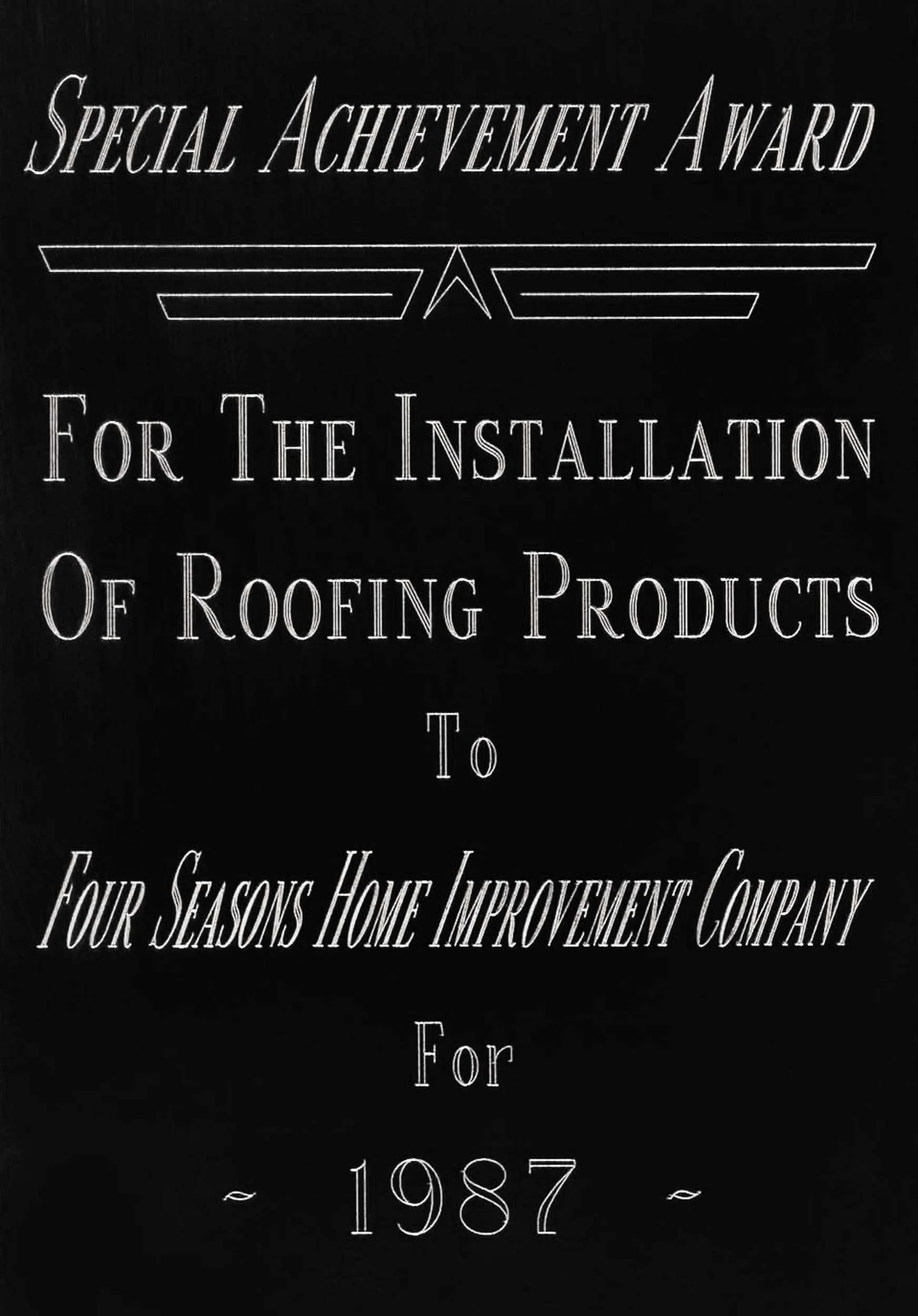 Black award plaque with silver text titled "Special Achievement Award for the Installation of Roofing Products to Four Seasons Home Improvement Company for 1987."