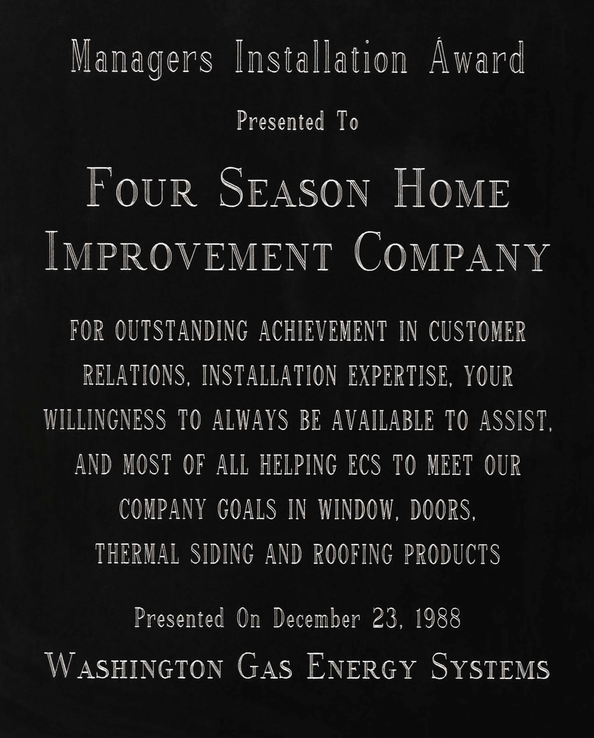 Black plaque with white text awarding Four Season Home Improvement Company for customer relations, installation expertise, and helping meet company goals, dated December 23, 1988, from Washington Gas Energy Systems.