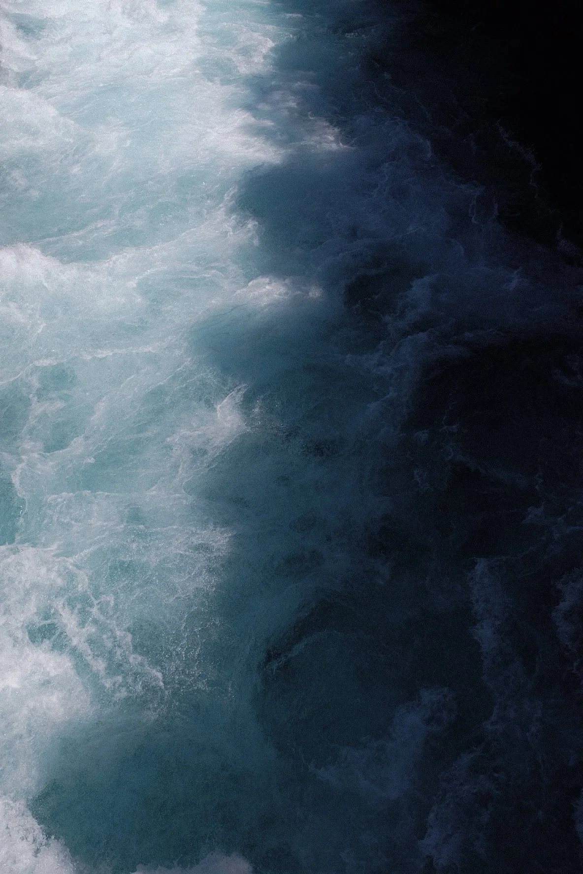 Close-up of turbulent blue ocean water with white foam
