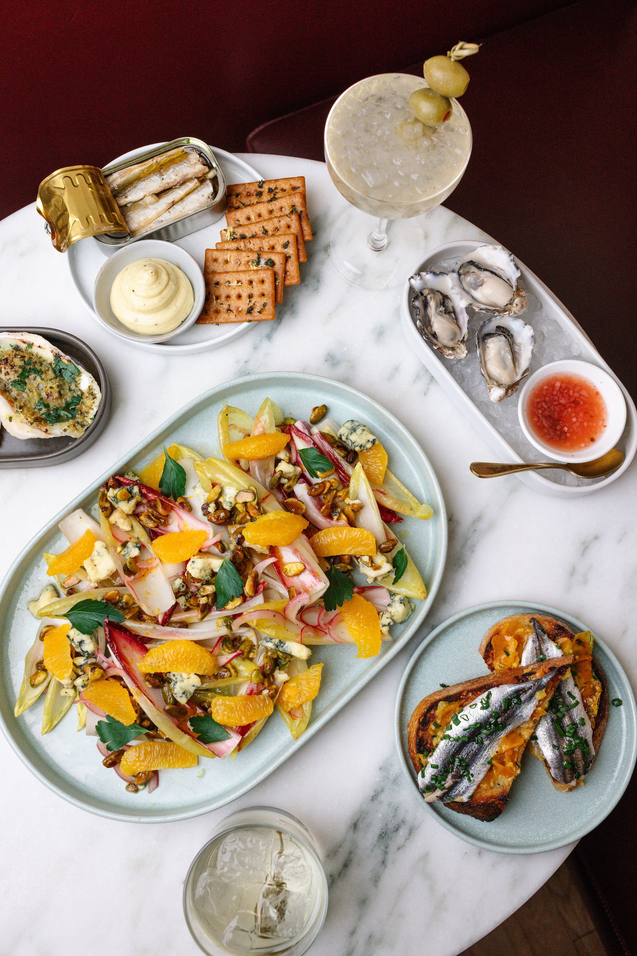 A curated selection of food and cocktails at Shy Shy in Chelsea, NYC, featuring oysters, seasonal salads, and a signature martini. Perfect for private dining, events, and elevated cocktail experiences.