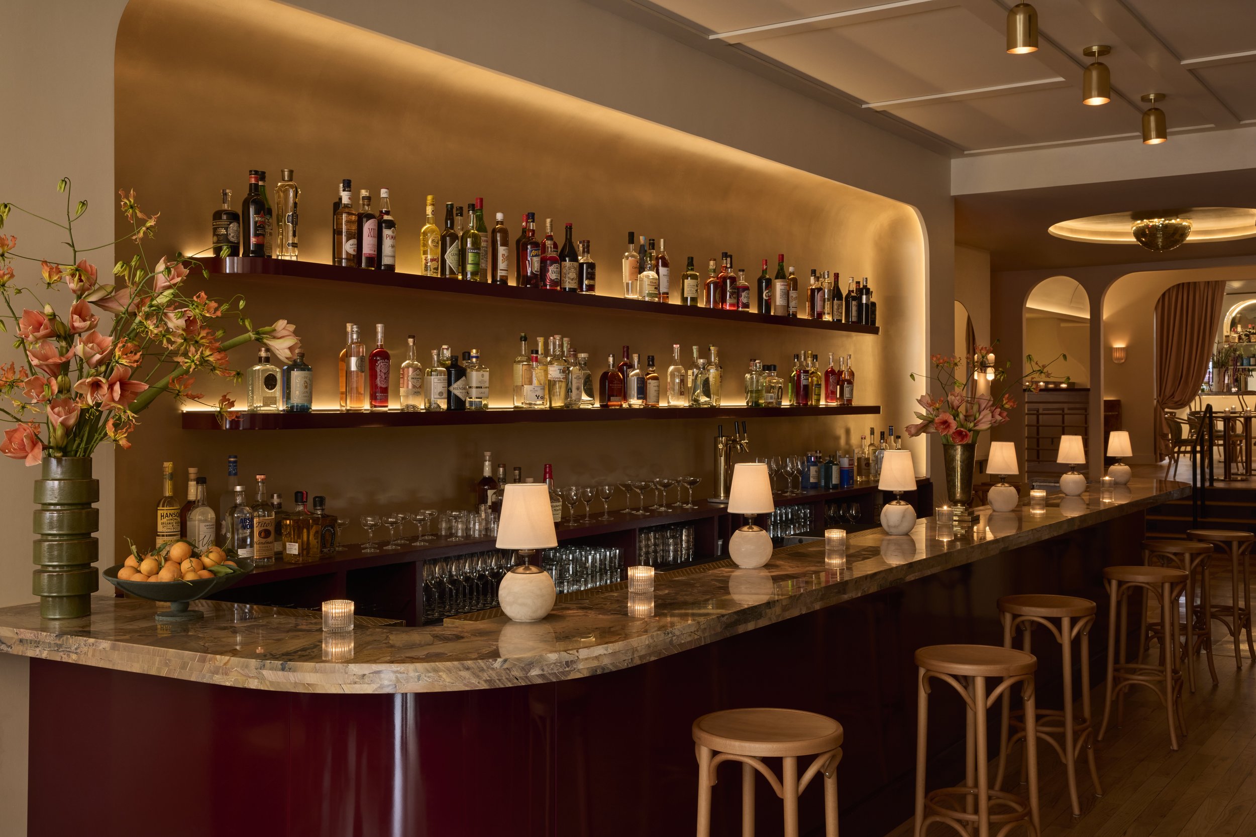 Shy Shy's elegant cocktail bar in Chelsea, NYC, featuring a sleek marble bar, warm ambient lighting, and a curated selection of premium spirits. A top destination for craft cocktails, martinis, and private events in Manhattan.