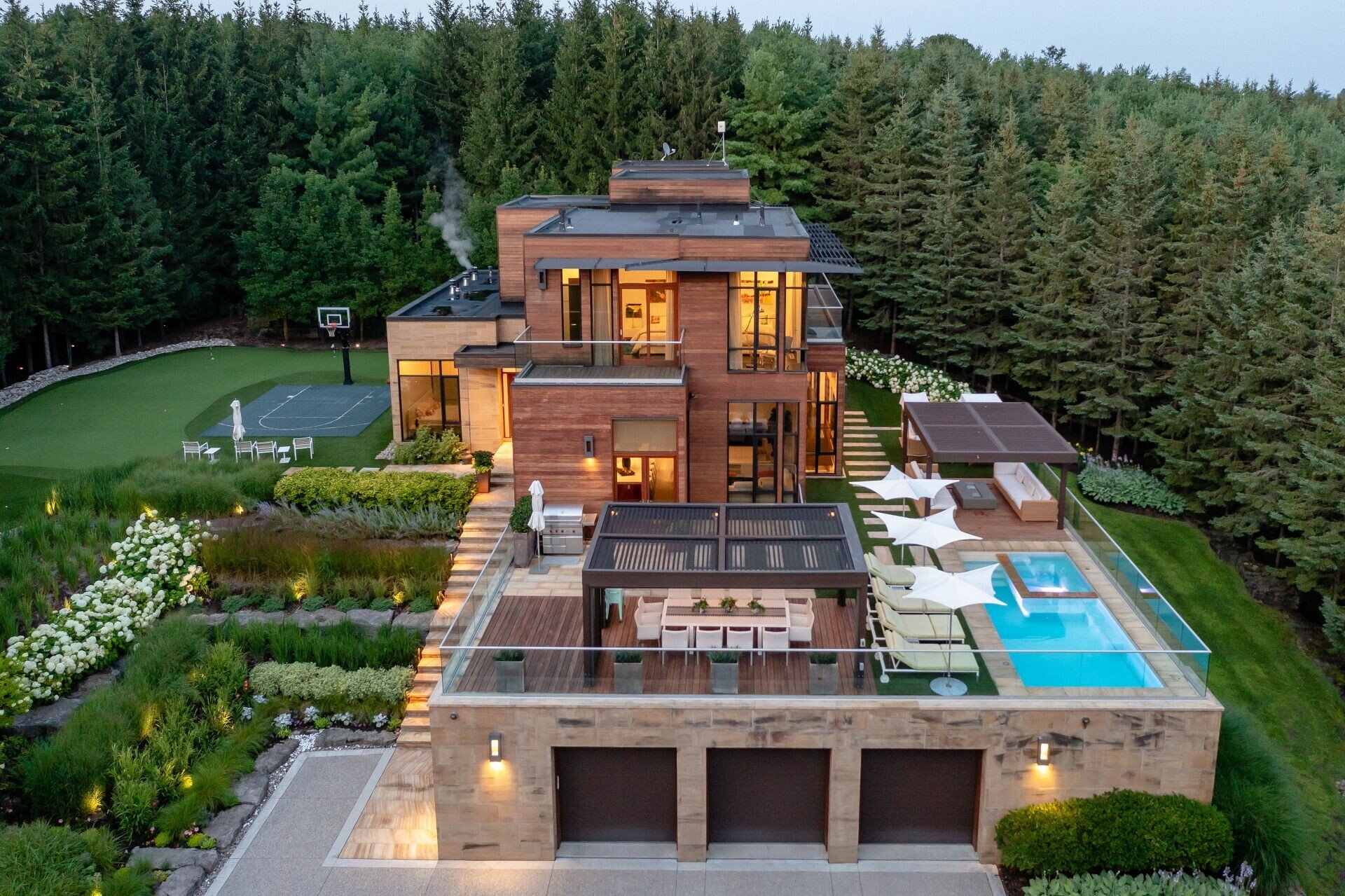 Beautiful custom landscape design featuring basketball court and elevated pool