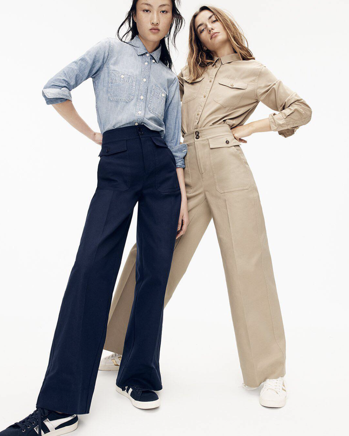 Two women posing in casual outfits, wearing high-waisted wide-leg pants and button-up shirts, with sneakers on a white background.