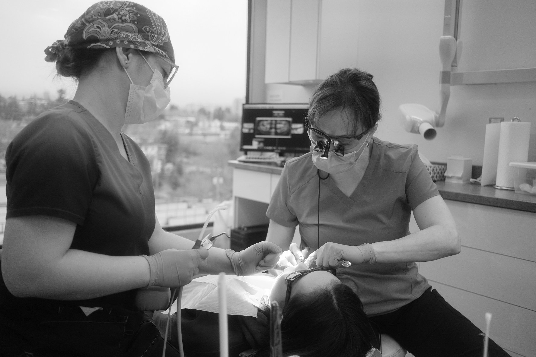 Dr. Janna Kuanysheva performing a dental procedure on a patient in a clinic.
