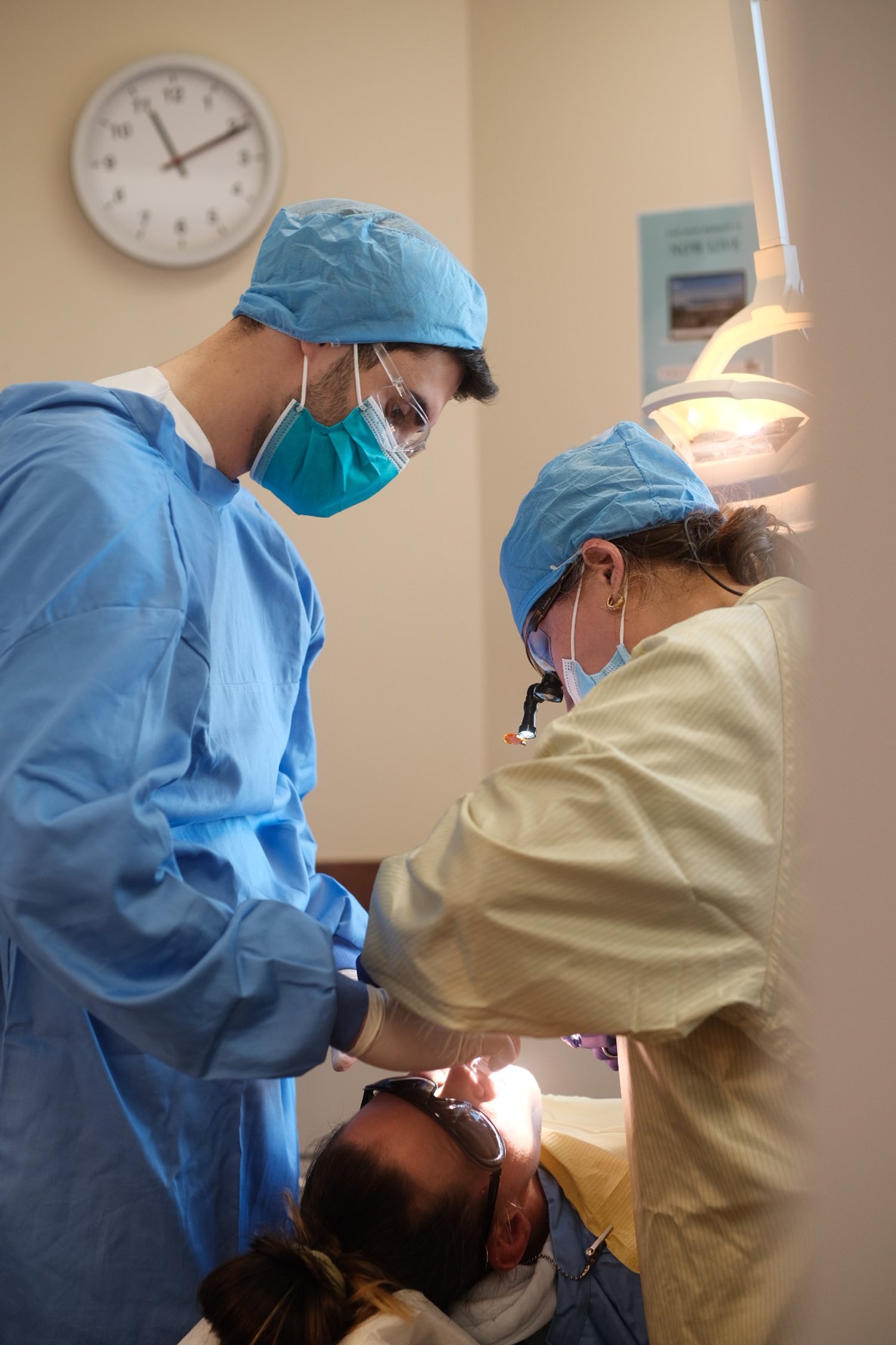 Dr. Janna Kuanysheva performing dental procedure on patient in clinic.