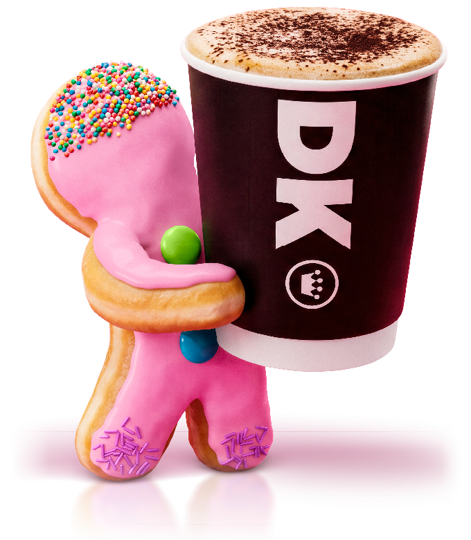 Pink decorated cookie with sprinkles and colorful candies next to a black cup of DQ coffee with foam on top.