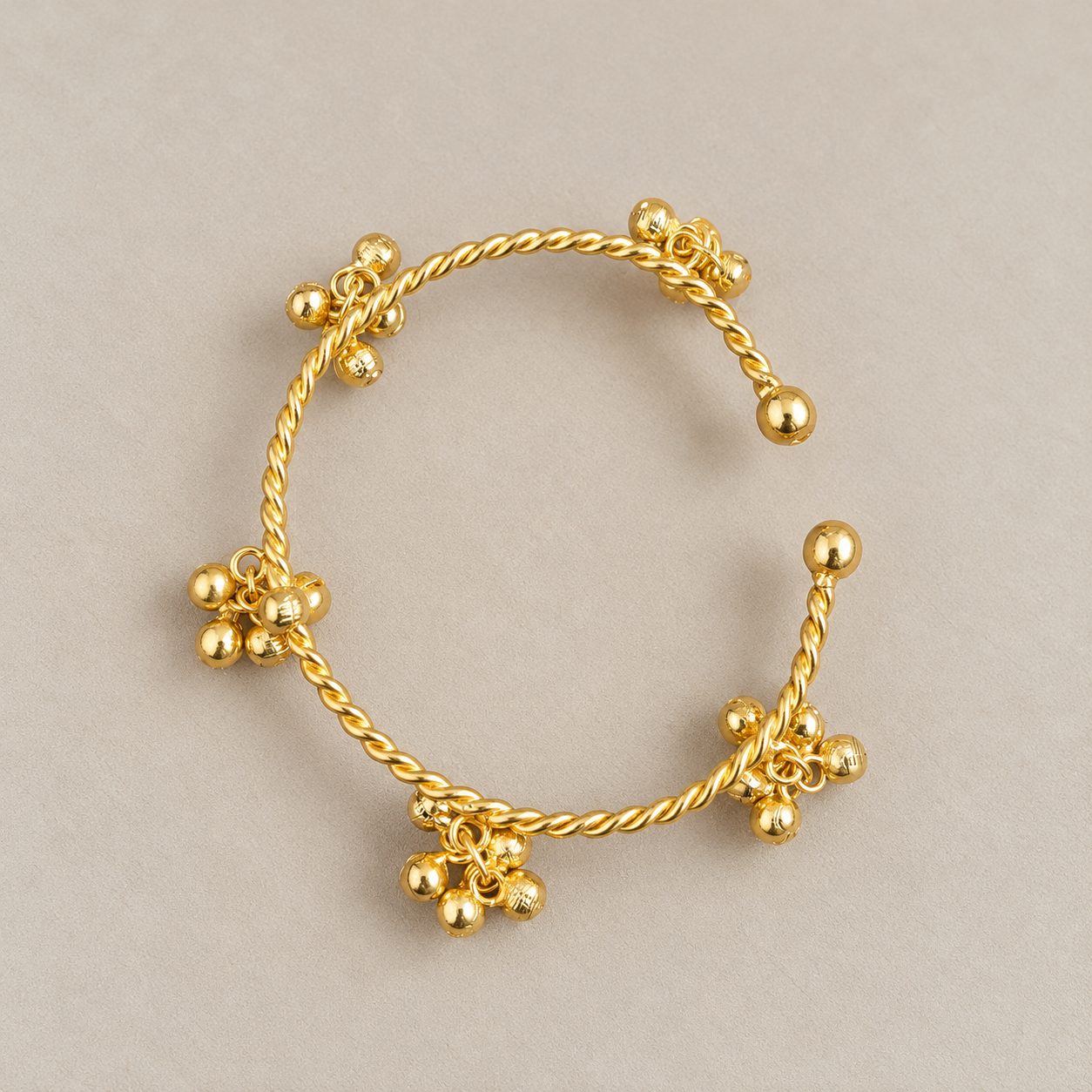 Twisted Gold Charm Cuff on Beige.png
