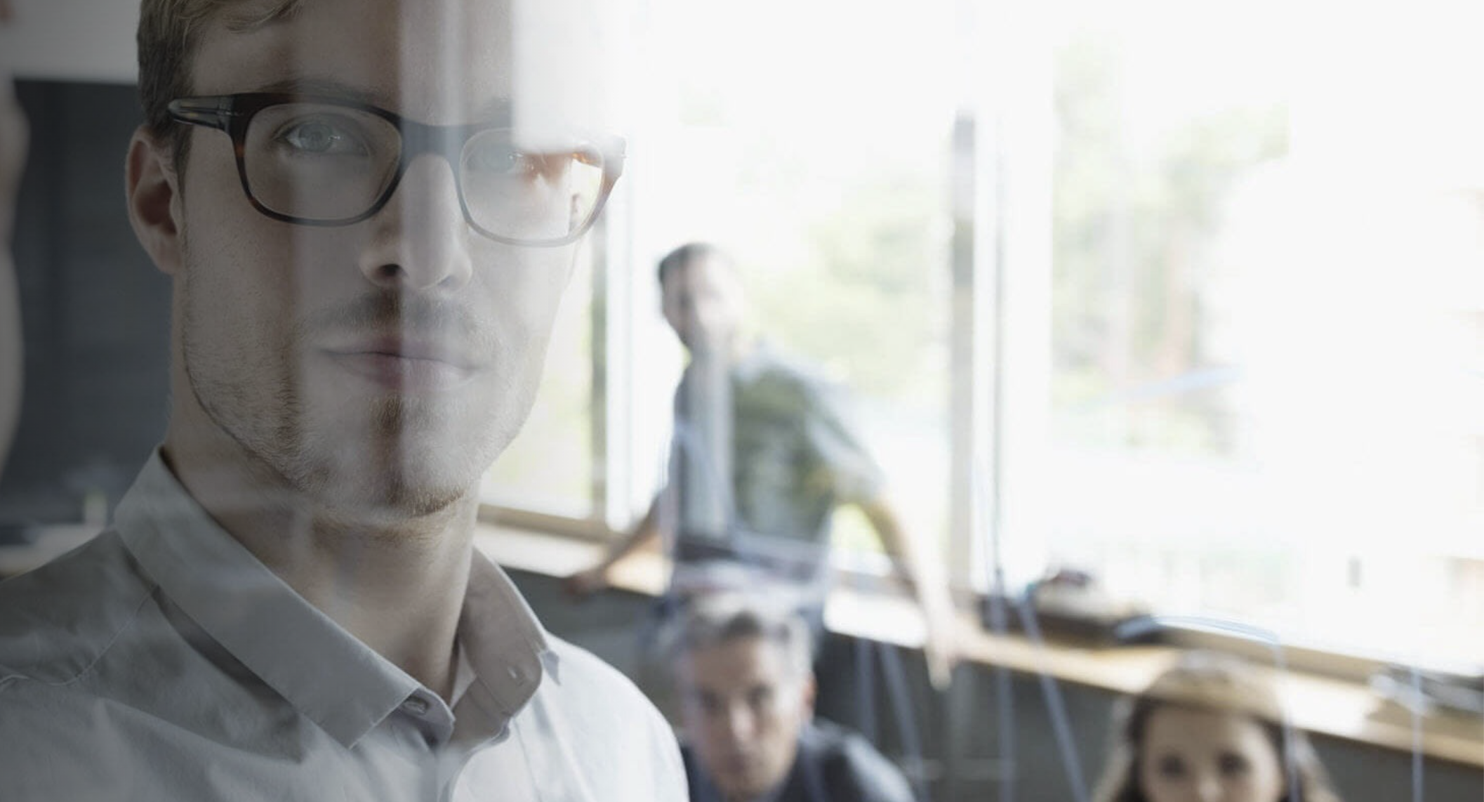 A glasses-wearing professional considers the impact of AI transformation