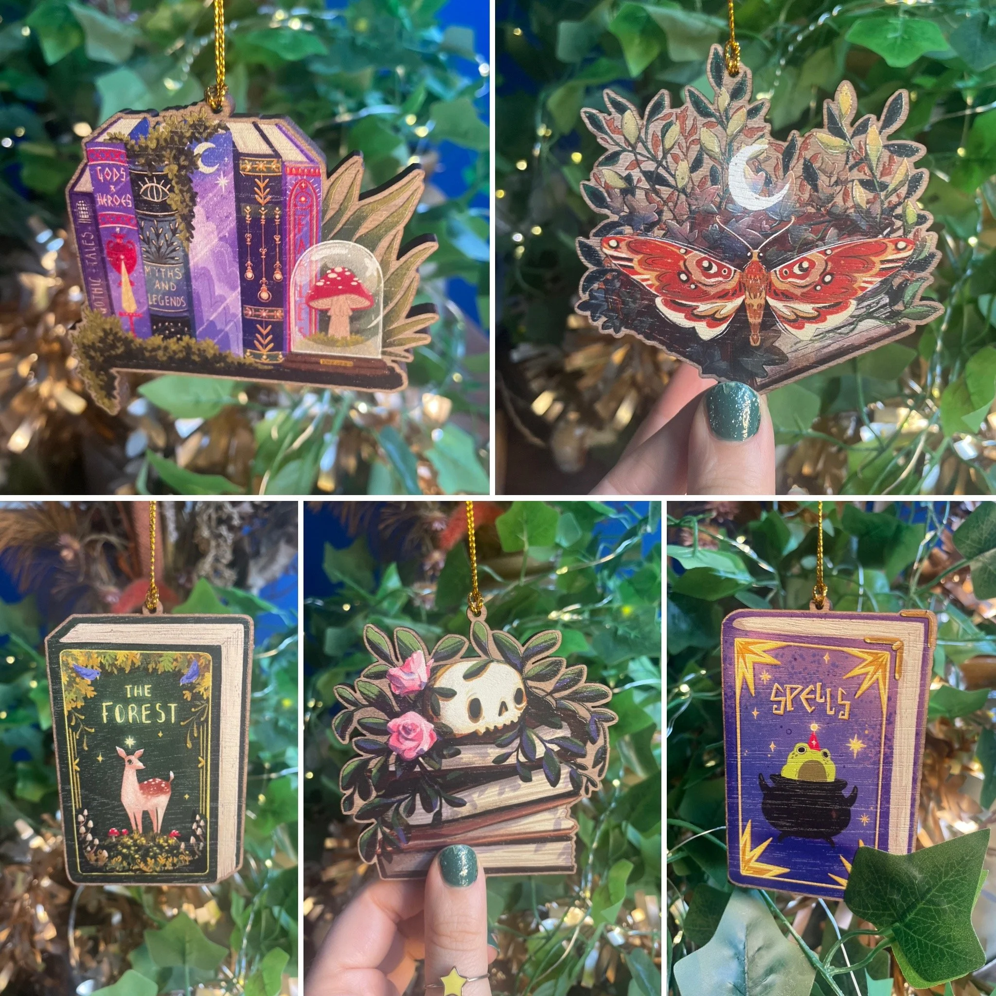 Set of five witchy book-themed printed wooden ornaments with books, and magic motifs against a background of green foliage and fairy lights.