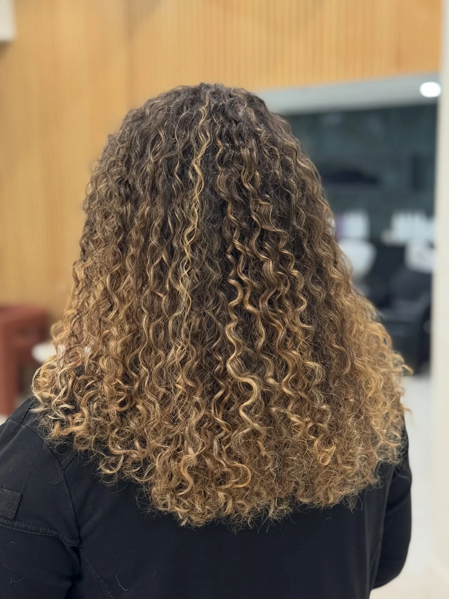 Custom curly cut and highlights designed for balance, movement, and low maintenance.

Every piece of color is placed to enhance the natural curl pattern, not disrupt it. The goal is dimension that grows out seamlessly and keeps your curls looking ful