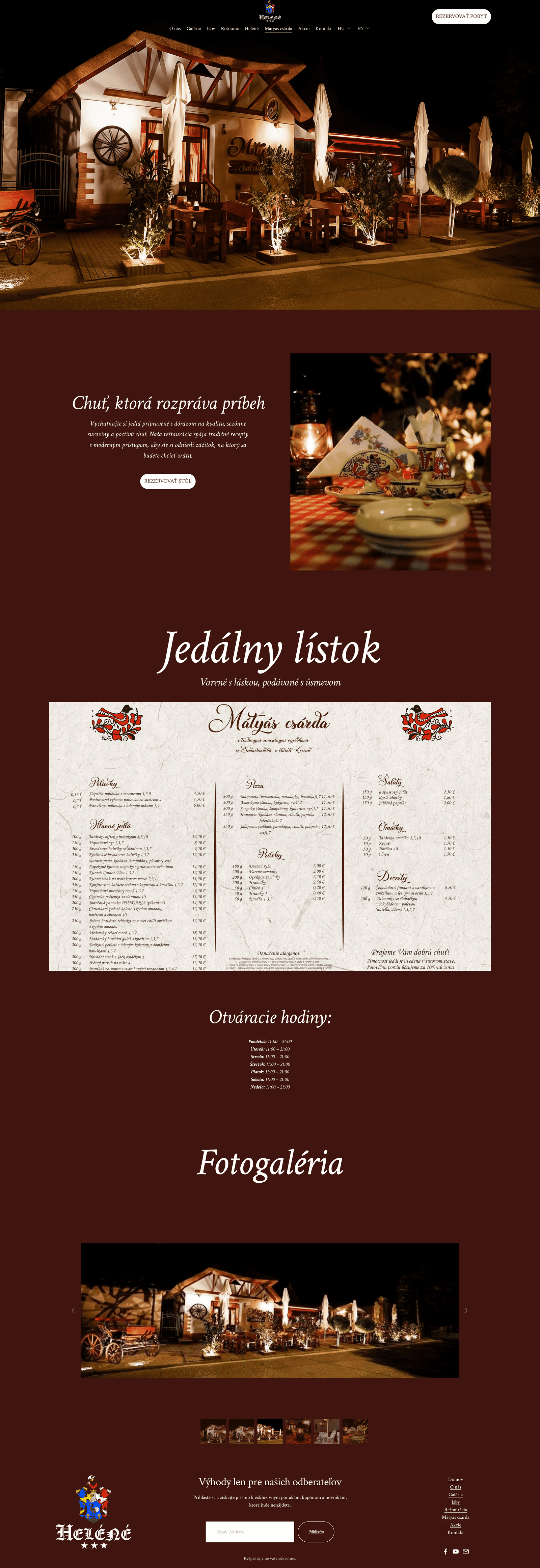 Exterior of a cozy restaurant or cafe with outdoor seating area illuminated at night, featuring wooden tables, benches, umbrellas, and decorative plants.