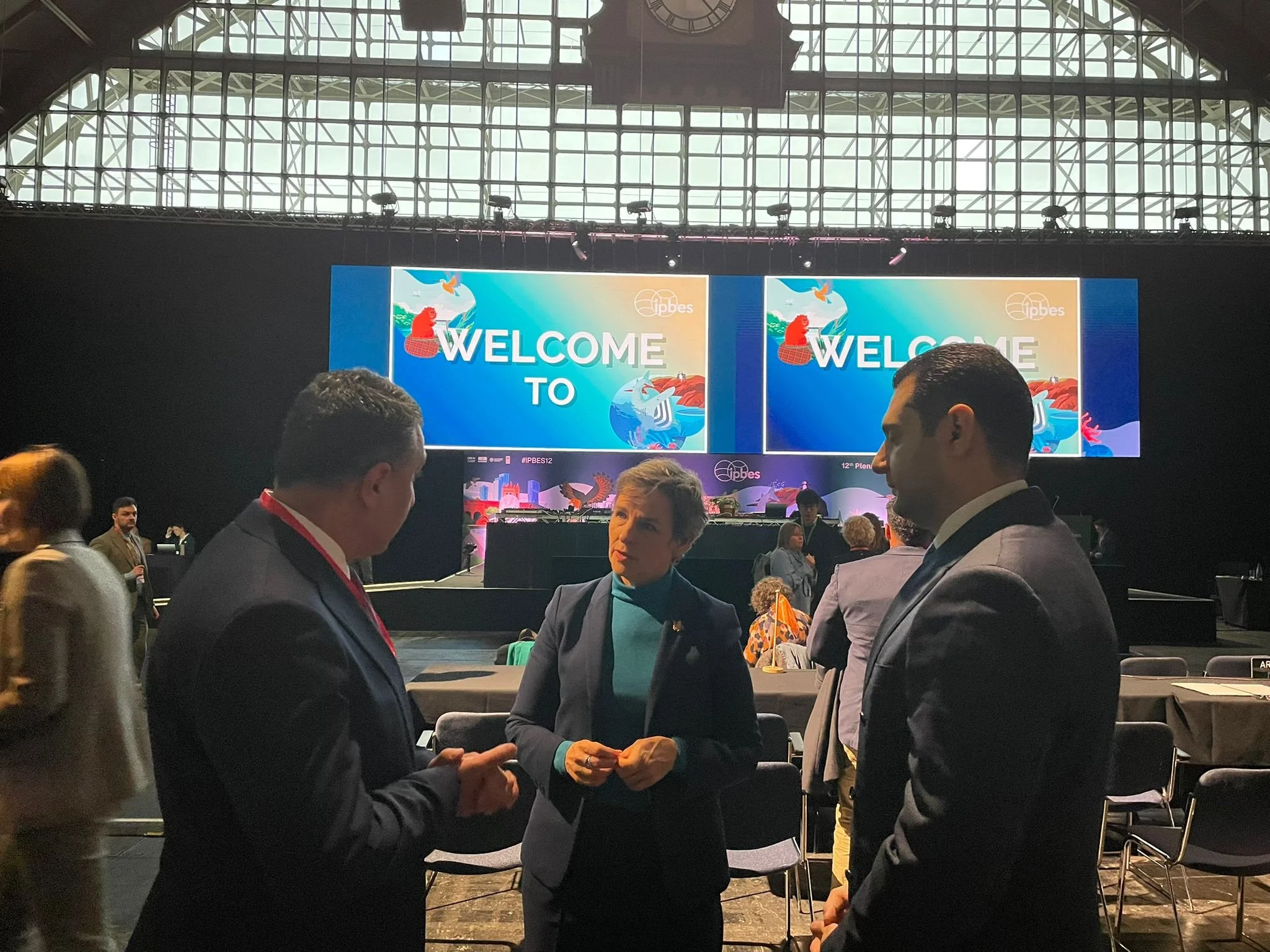 Mary in discussion with two men.jpeg