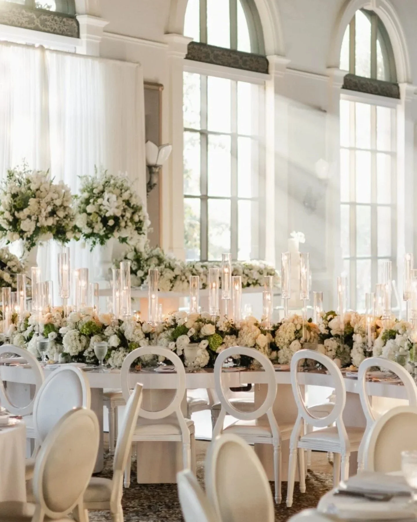 Luxury indoor wedding reception featuring a floral tablescape with green florals, tall urn arrangements, and candlelit romance 🕯️🌸 Designed to perfection with mojito hydrangeas, lizzies and textured blooms for a modern, elegant ambiance. 

#Wedding