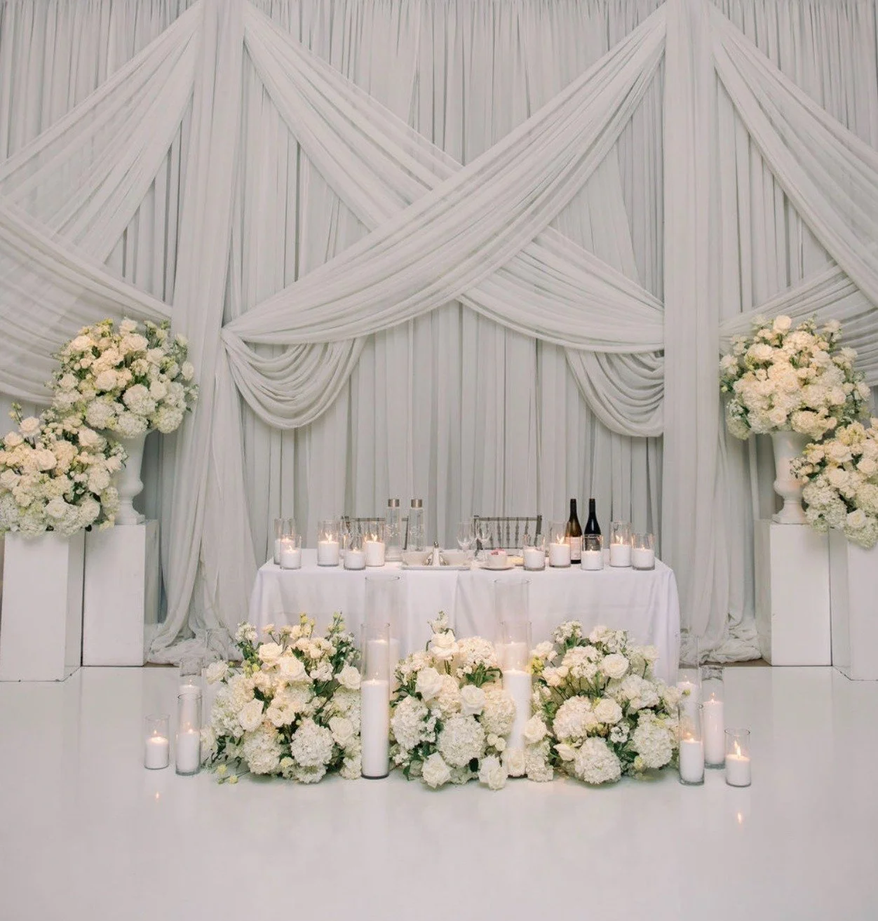 As seen in the photo &mdash; grand urn arrangements on plinths framing the space, and a sweetheart table dressed with lush florals and tall sandwax candles.

📸 @emily_michelson 

#LuxuryWedding #TorontoWedding #FloristToronto #BloomberryandCo