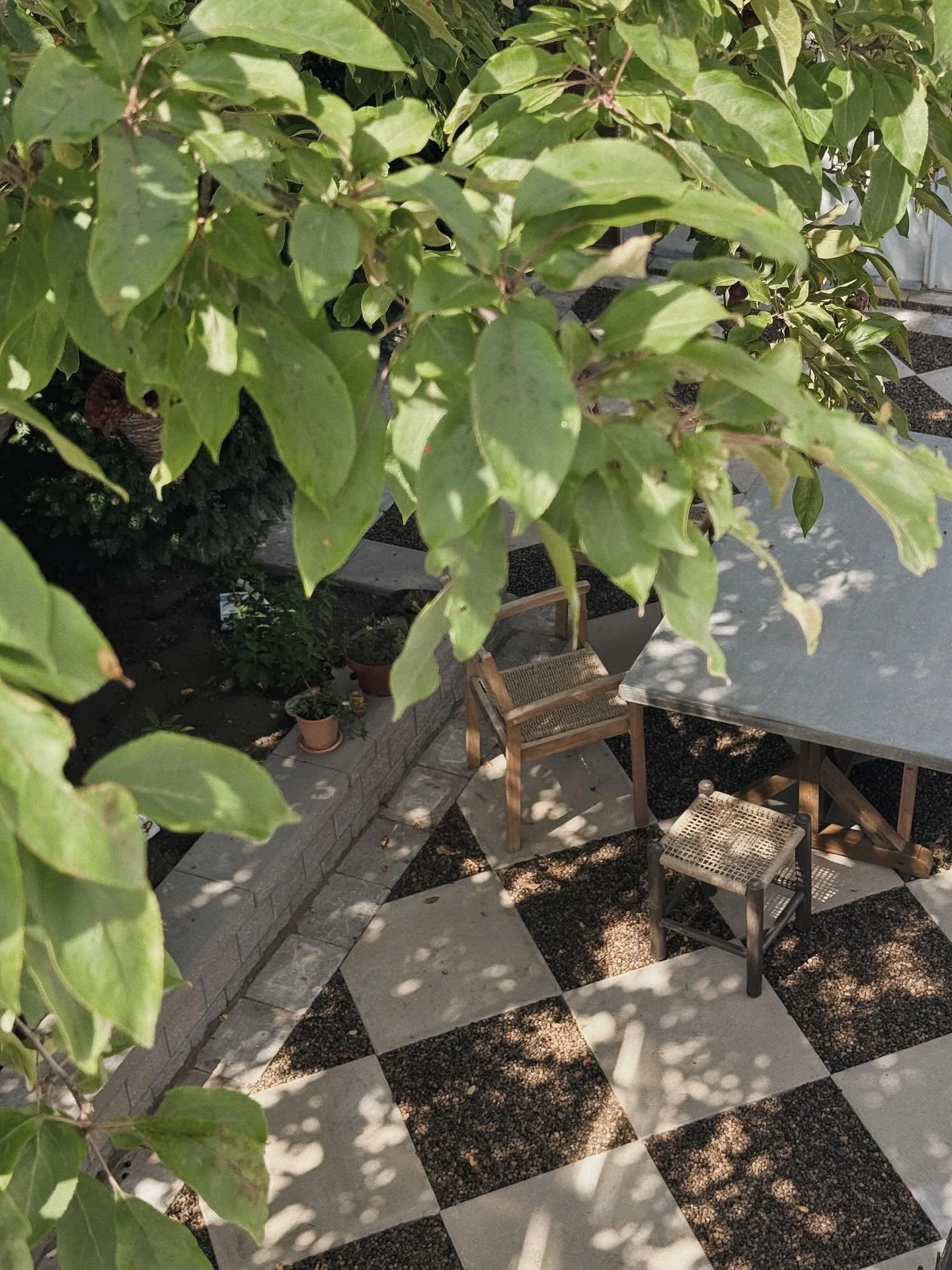 Where light dances and stone remembers.
This harlequin patio was designed to feel timeless&mdash;where the geometry is bold, but the mood is soft. Anchored by wood, terracotta, and the hush of greenery overhead, it&rsquo;s a quiet moment of soulfulne
