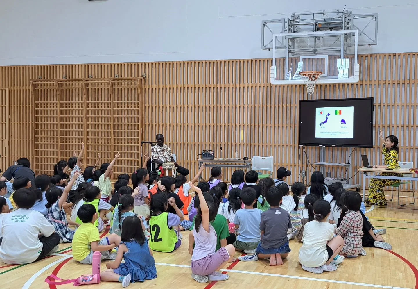 【杉並区立杉並和泉学園で公演してきました🎶】

今回はワガンさんと2人で、スライドを使いながらセネガルやアフリカについて紹介しつつ、演奏は3曲お届けしました🎵
さらに、手遊びや簡単なダンスも取り入れて、みんなで身体を動かしながら楽しみました✨

約100名の小学生と20名ほどの先生方が参加してくださり、会場は元気いっぱいの熱気に包まれました！
先生たちは「1時間も集中力がもつかな？」と少し心配されていましたが、実際には時間が足りないくらい！
子どもたちの目がキラキラしていて、「もっとやりたい