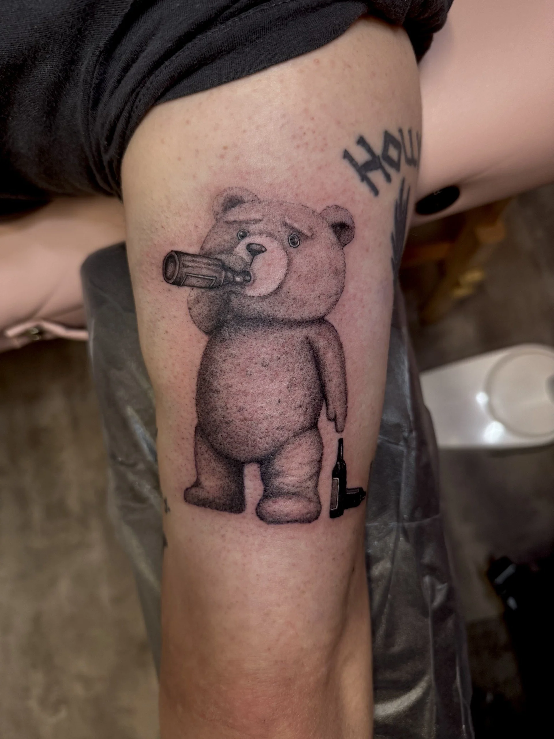 Tattoo of a bear on a person's upper arm.