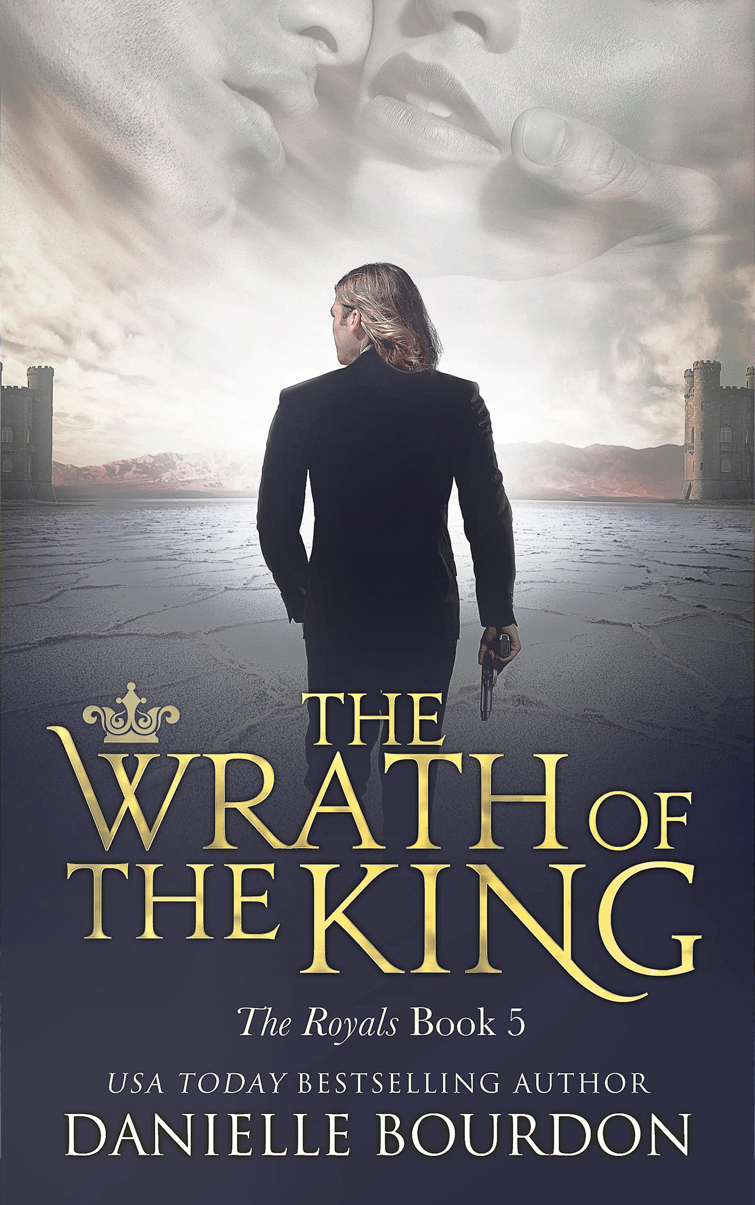 Book cover for 'The Wrath of the King' by Danielle Bourdon, showing a man with long hair in a black suit holding a gun, walking toward a distant castle on a cracked, icy landscape, with large ghostly faces in the sky.
