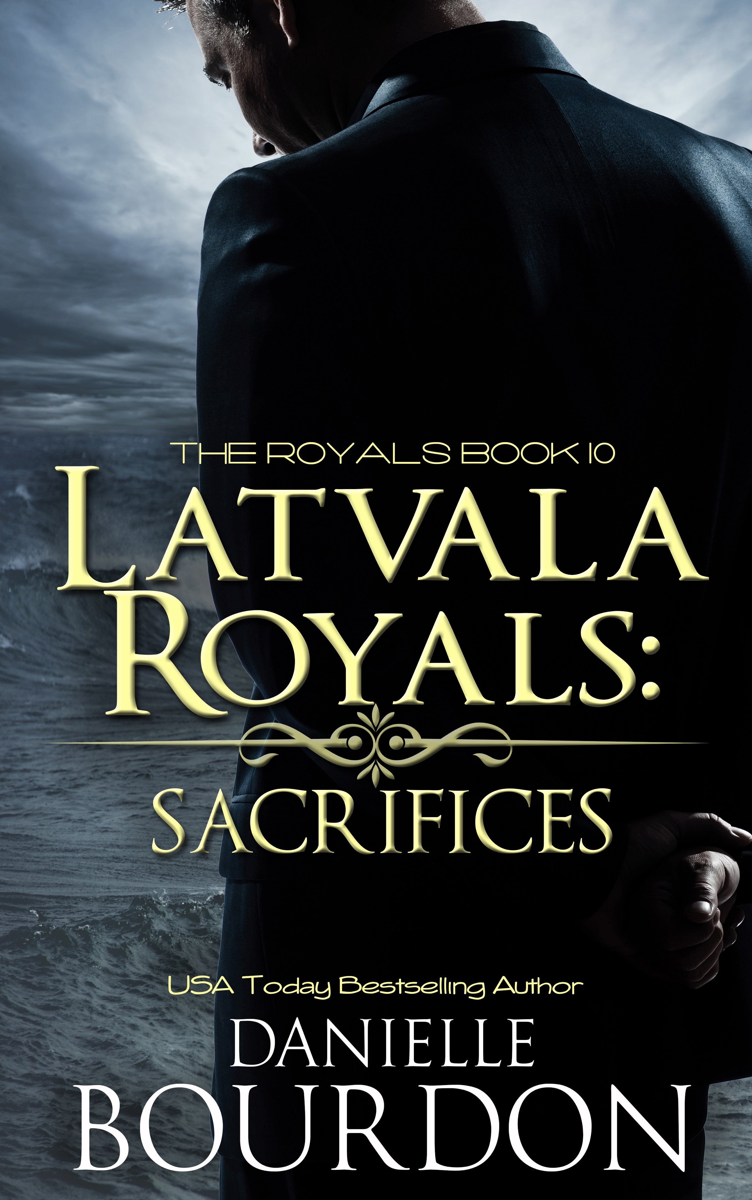 Book cover for 'The Royals Book 10: La Val Royals: Sacrifices' by Danielle Bourdon, featuring a man in a dark suit with a hand clasped behind his back, standing near the ocean under a gray cloudy sky.
