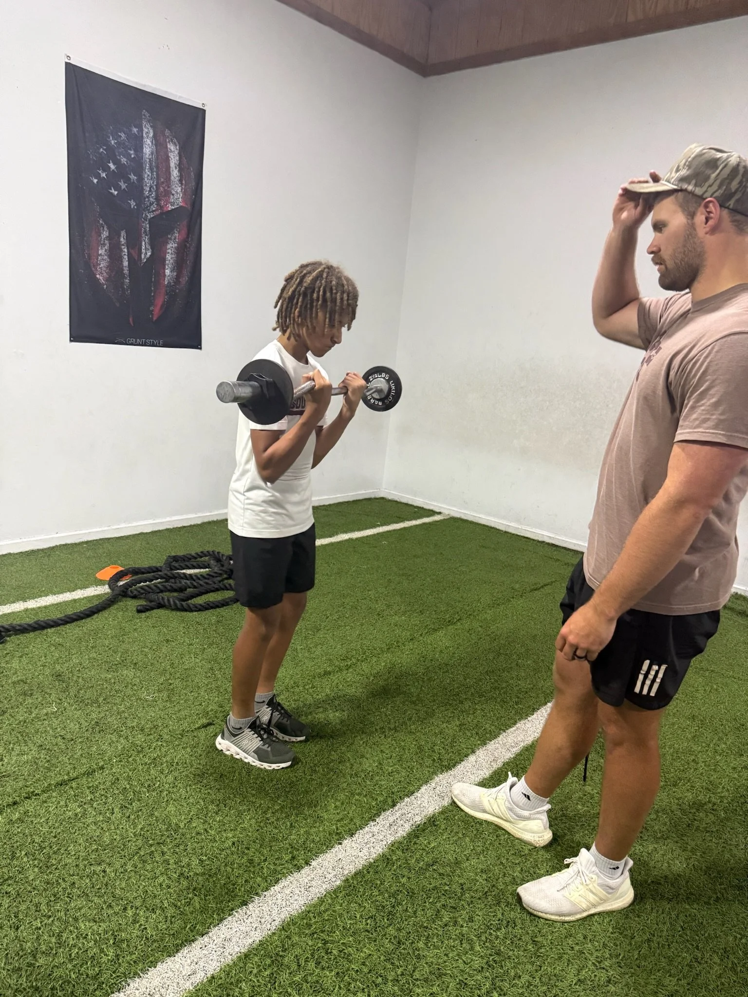 Athlete doing bicep curls with Coach Jackson.