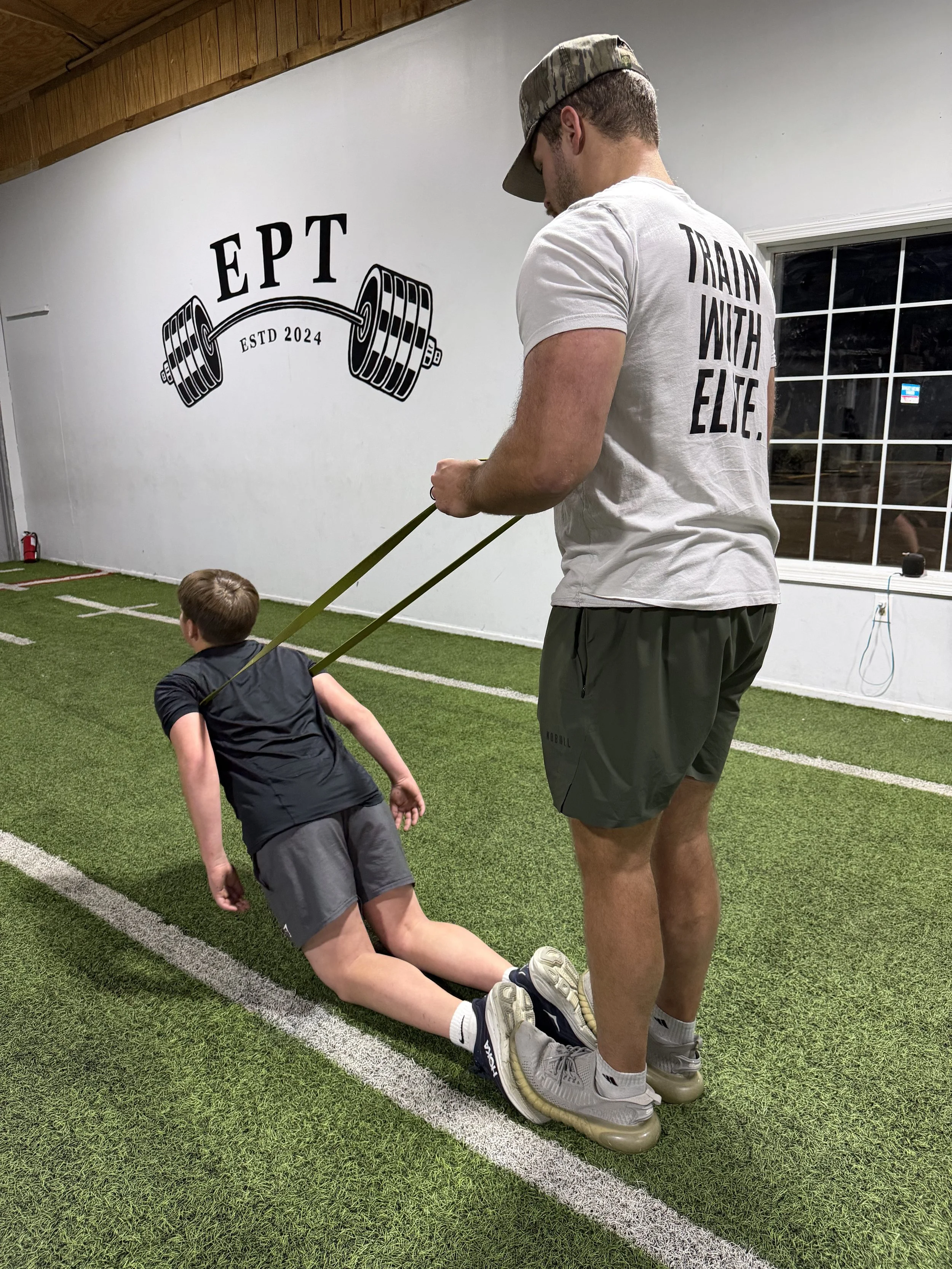 Coach Jackson spotting an athlete with resistance band training.
