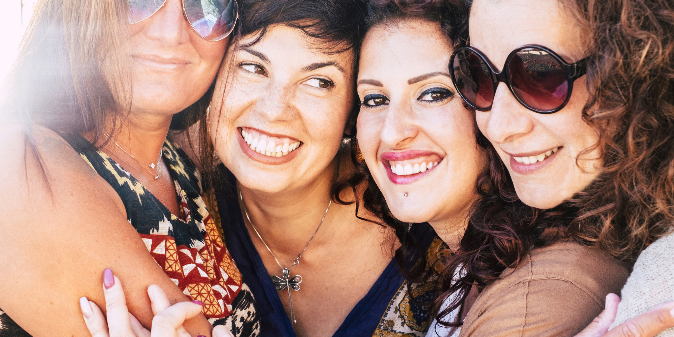 Four women from a Miami Sacred Feminine retreat sharing connection, empowerment, and embodied leadership through immersive transformation work.