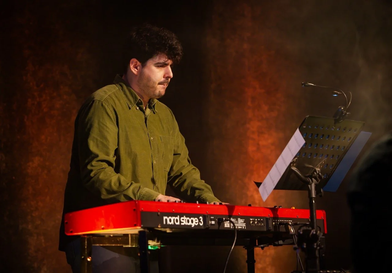 Musician playing a Nord Stage 3 keyboard on stage with music stand