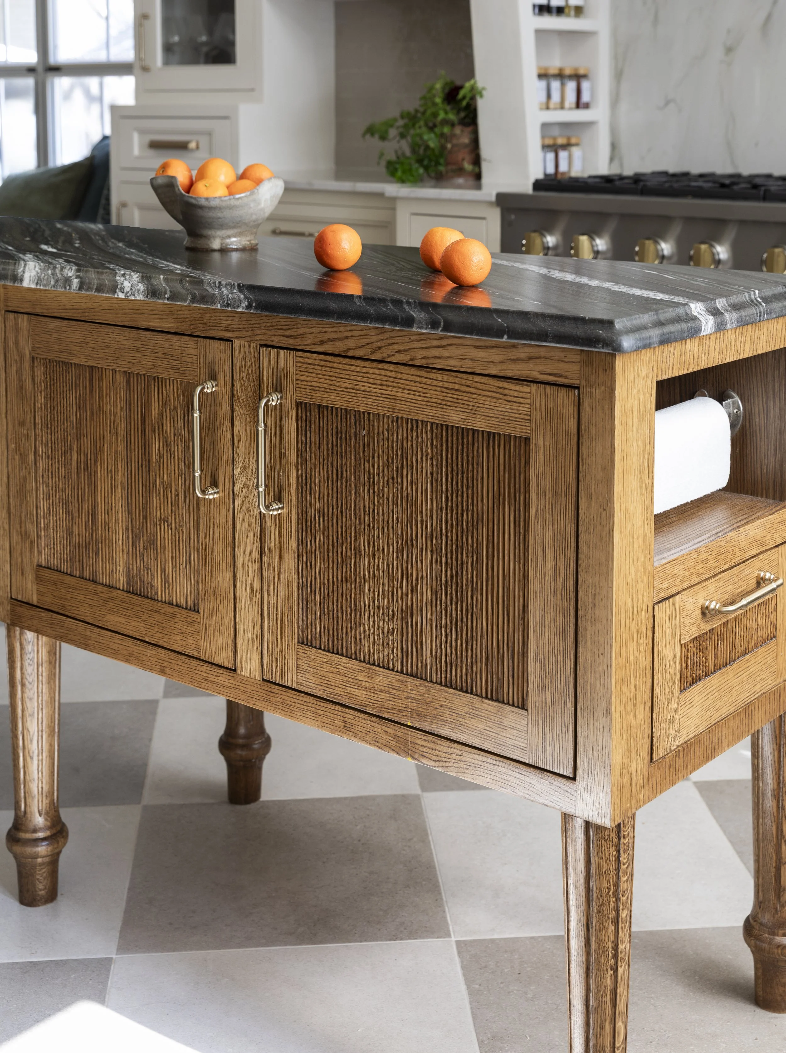 Custom furniture island designed by Paula Dixon Design in Houston to offer maximum user ability such as paper towel holder. 