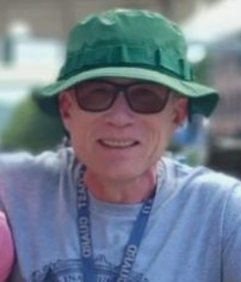 Person wearing a green bucket hat and sunglasses