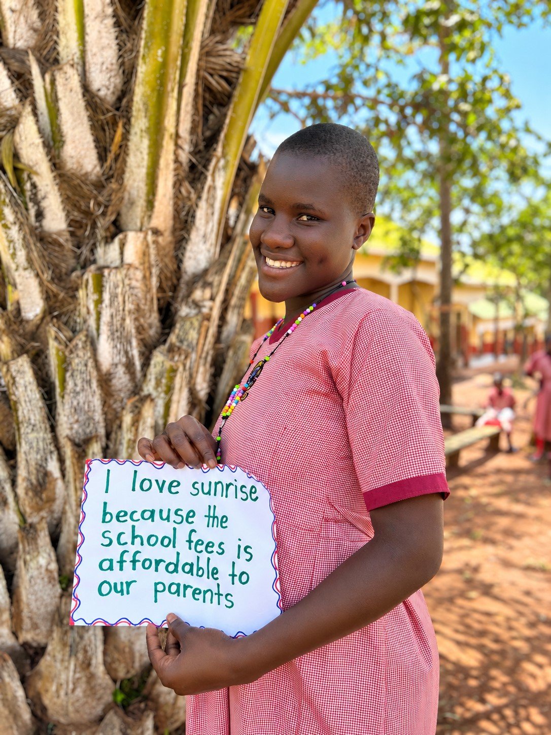 Smiling Student with School Fees Sign.jpg