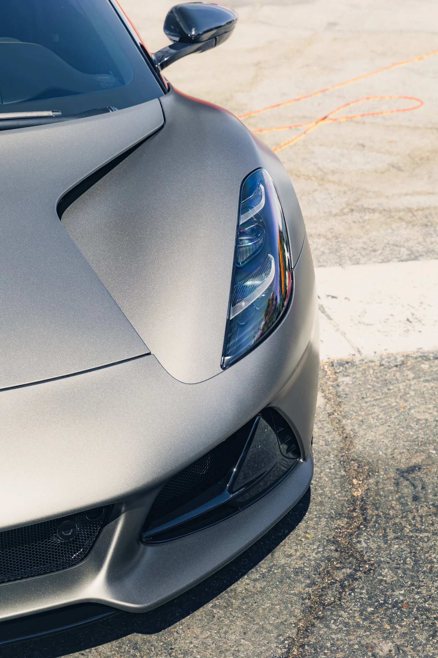 Front end of a matte metallic sports car, the look of a satin vinyl color change