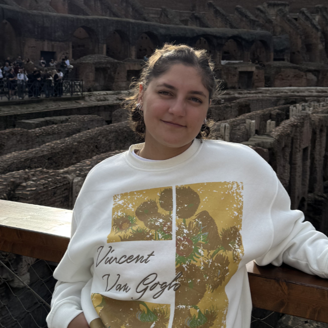 Portrait of our advisor, Ailén Serrano, a young woman in a white sweatshirt smiling at the camera.